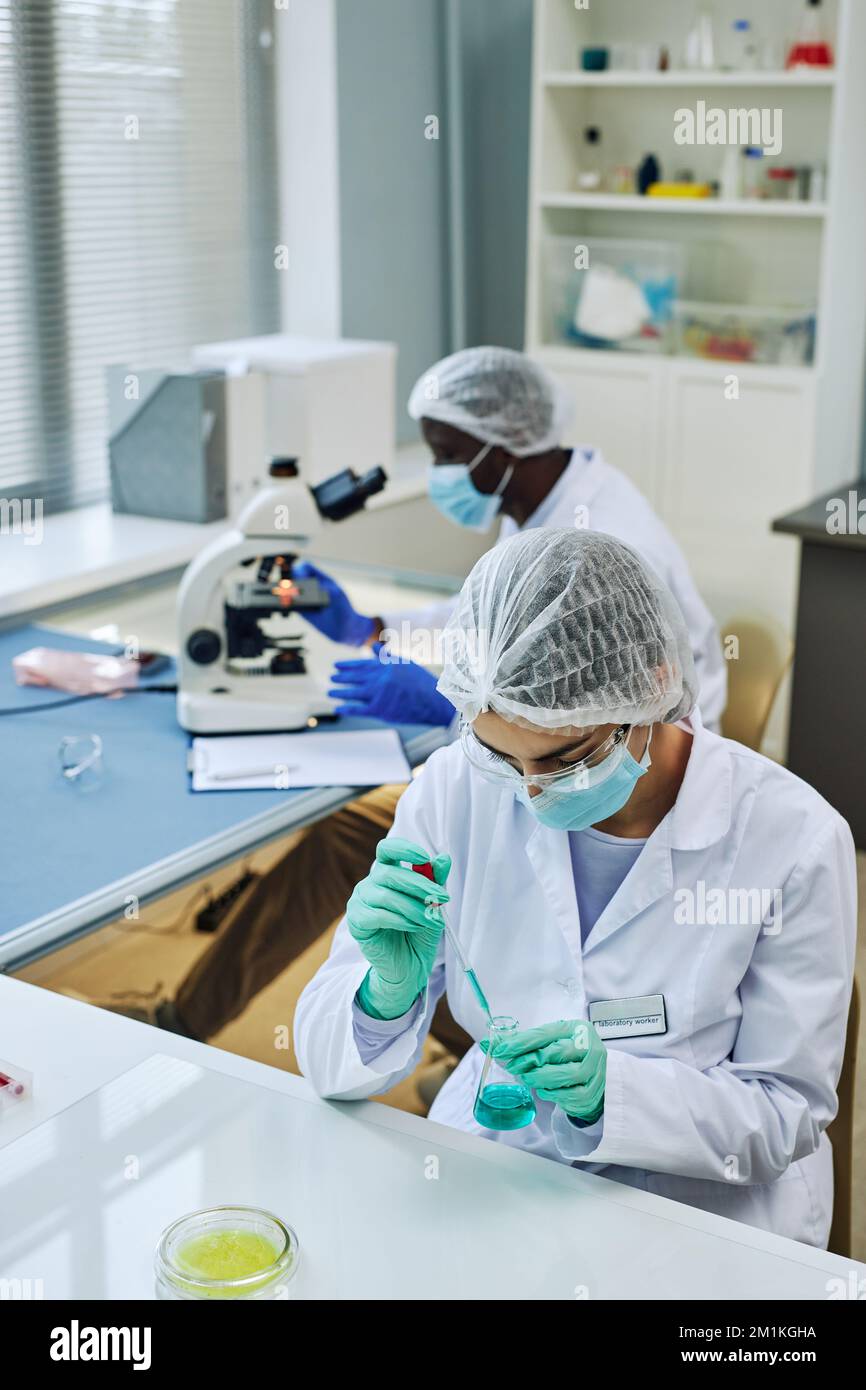 Vertical shot of medical laboratory with two scientists working on ...