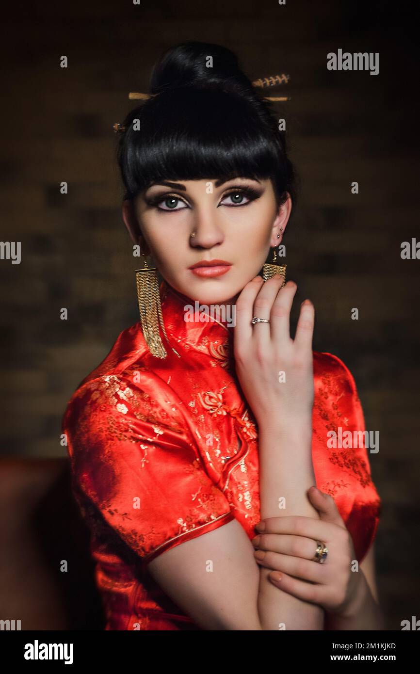 girl in a red Japanese silk dress qipao in a dark atmospheric room