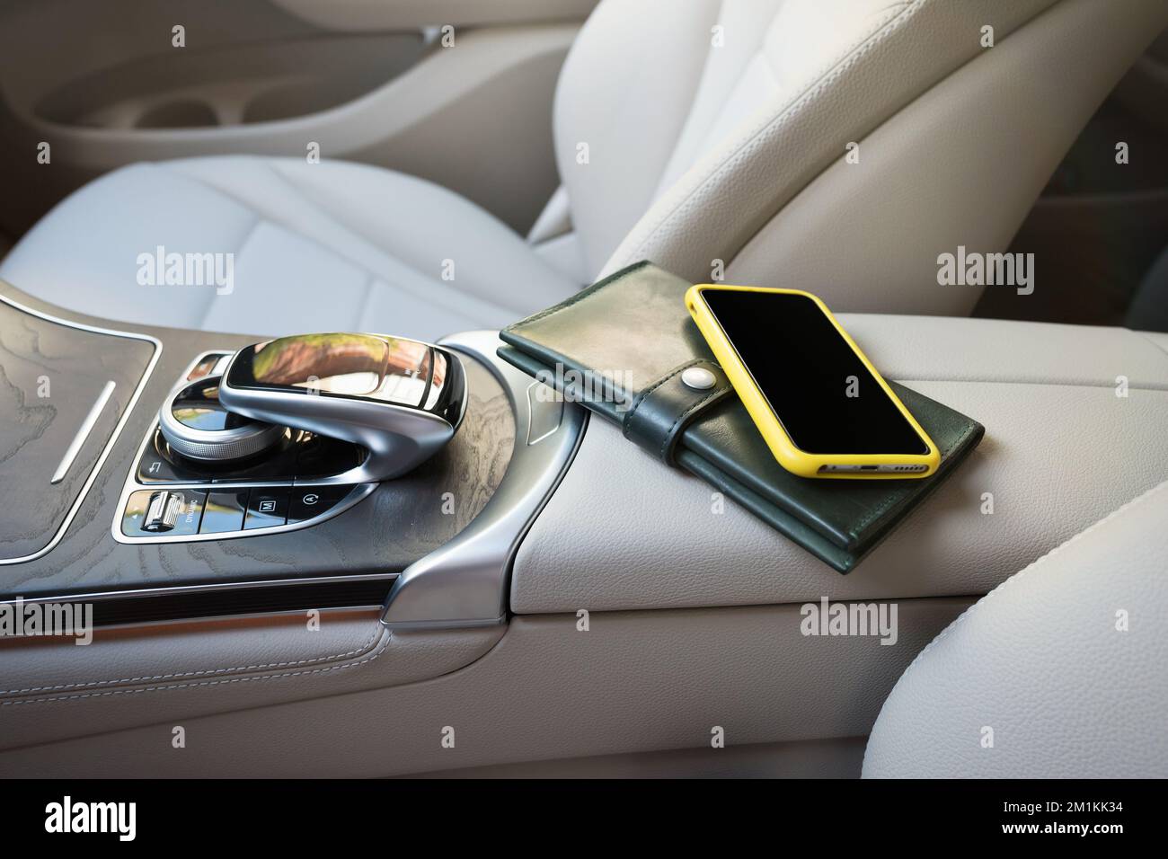 A telephone and purse lie on an elbowrest in the salon of car Stock