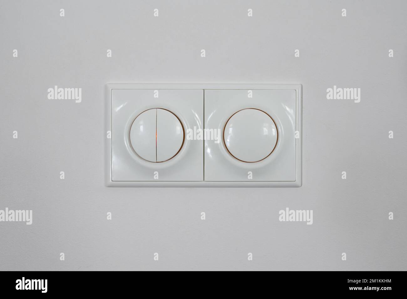 White switch on white wall. Regulator of electric switch of candle-power Stock Photo