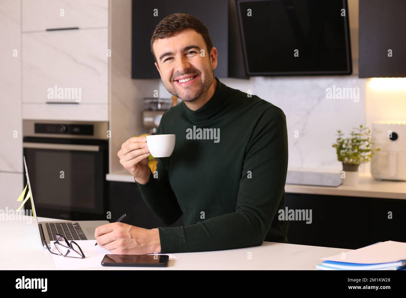 Man drinking a cup of coffee while working from home Stock Photo