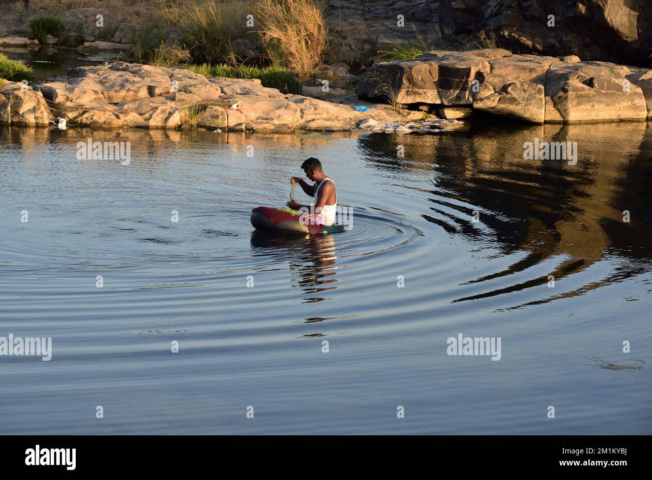 Fisherman fishing in tyre tube boat in river, Ghadoi, Valsad, Gujarat, India, Asia Stock Photo