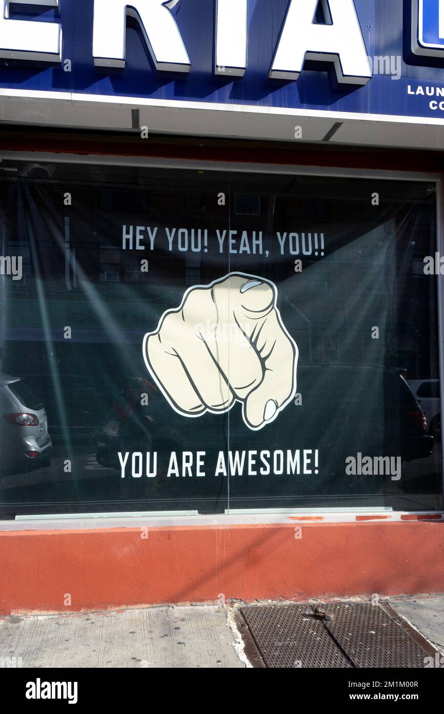 A sign outside a launderette pointing a finger and saying that you are awesome. In Corona, Queens, New York. Stock Photo