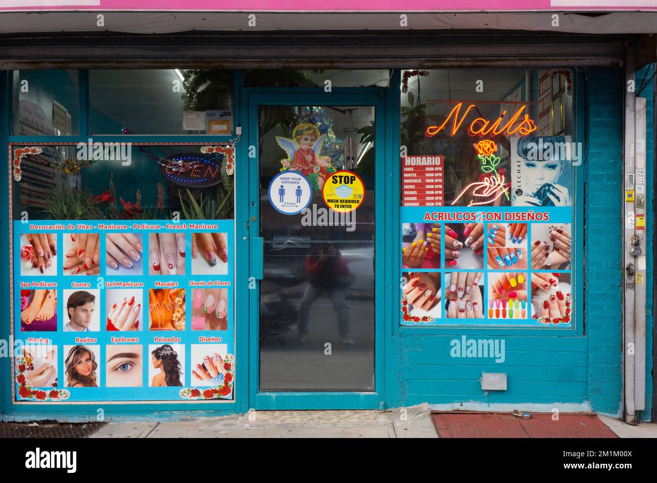 The exterior of Bella's Nail Salon Spa on 37th Avenue in Corona, Queens, New York. The signs are primarily in Spanish. Stock Photo