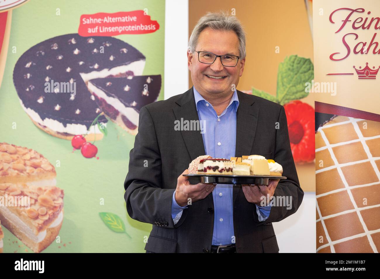 Mettingen, Germany. 13th Dec, 2022. Peter Schmidt, CEO of food manufacturer Coppenrath & Wiese, poses with a tray full of cake pieces at the company's annual press conference. The management of Germany's largest frozen baked goods manufacturer wants to take stock of the 2022 financial year and provide an outlook for 2023. Credit: Friso Gentsch/dpa/Alamy Live News Stock Photo