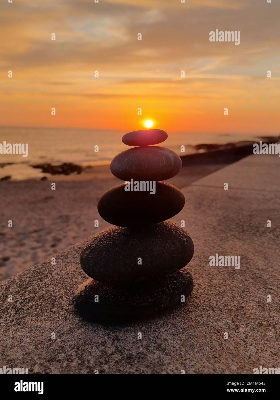 A stack of rocks on top of each other on the beach at sunset Stock ...
