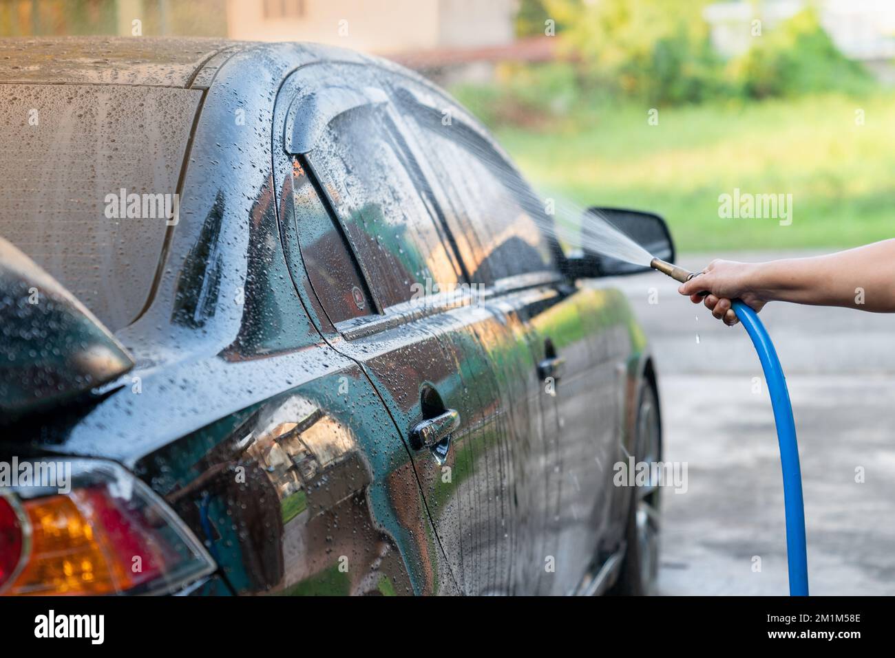Manual car wash with pressurized water on car wash outside. Spray water cleanning Stock Photo