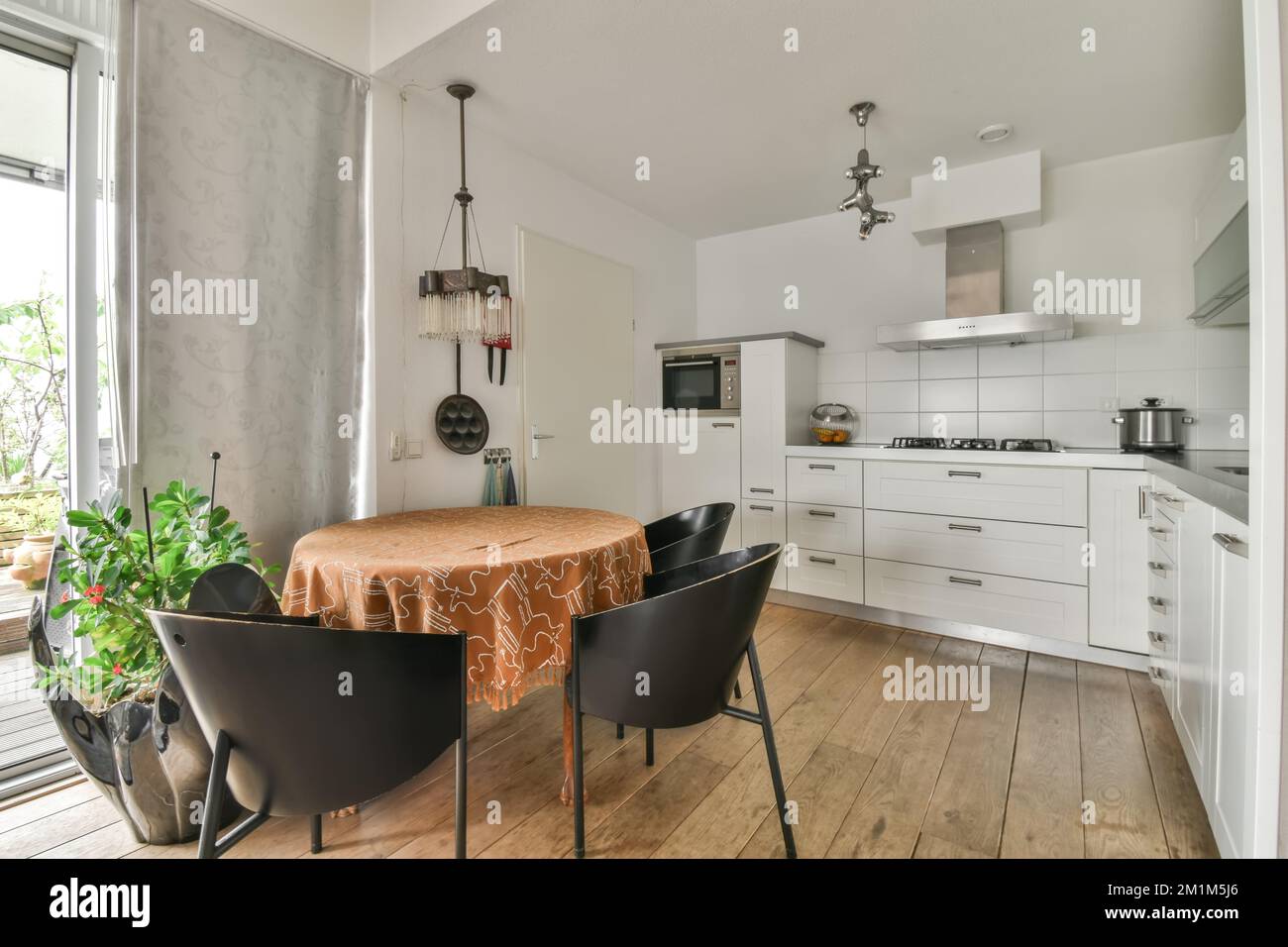 a dining table and chairs in a kitchen with an open window looking out