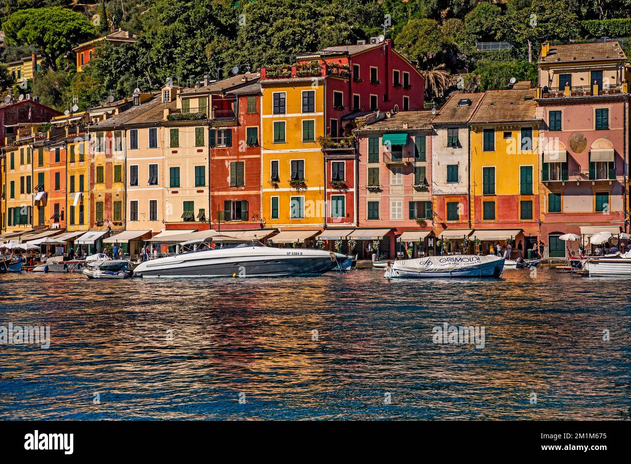 A river with ships and colorful traditional buildings in the background ...