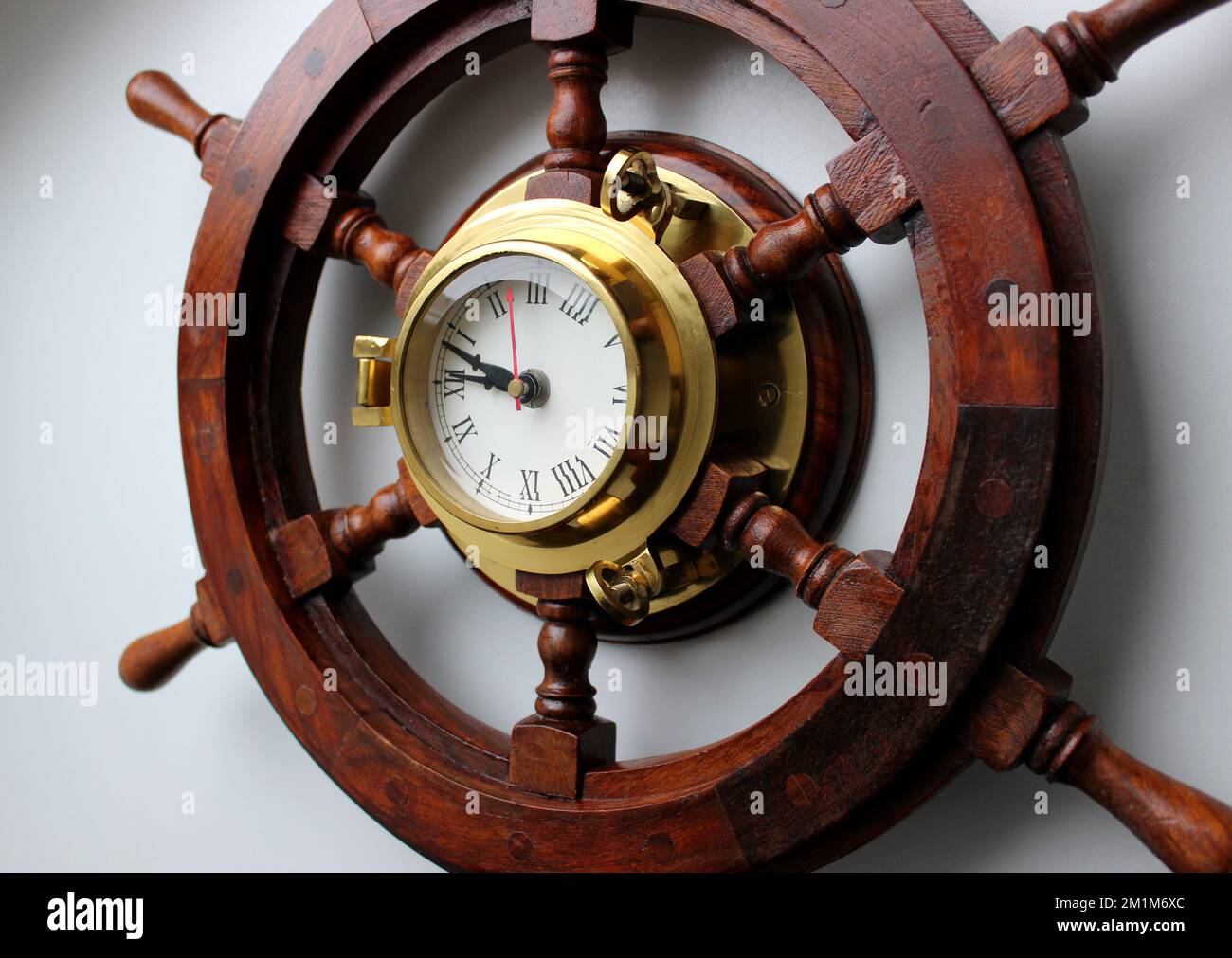 Pointer Clock With Copper Frame In A Center Of Wooden Helm Angle View Stock Photo