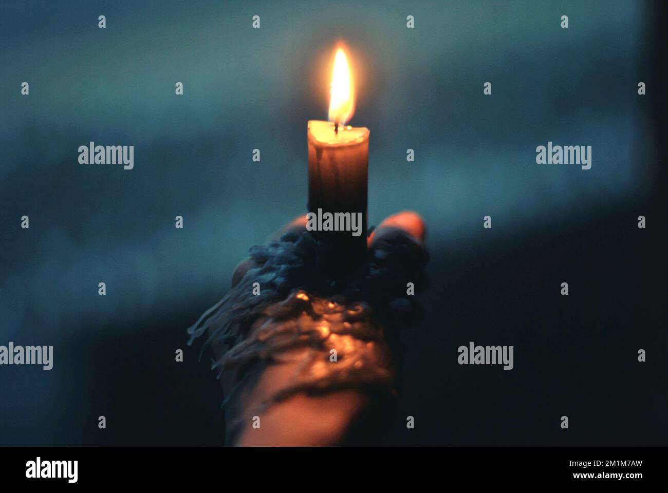 Candle being held by a hand and dripping wax Stock Photo