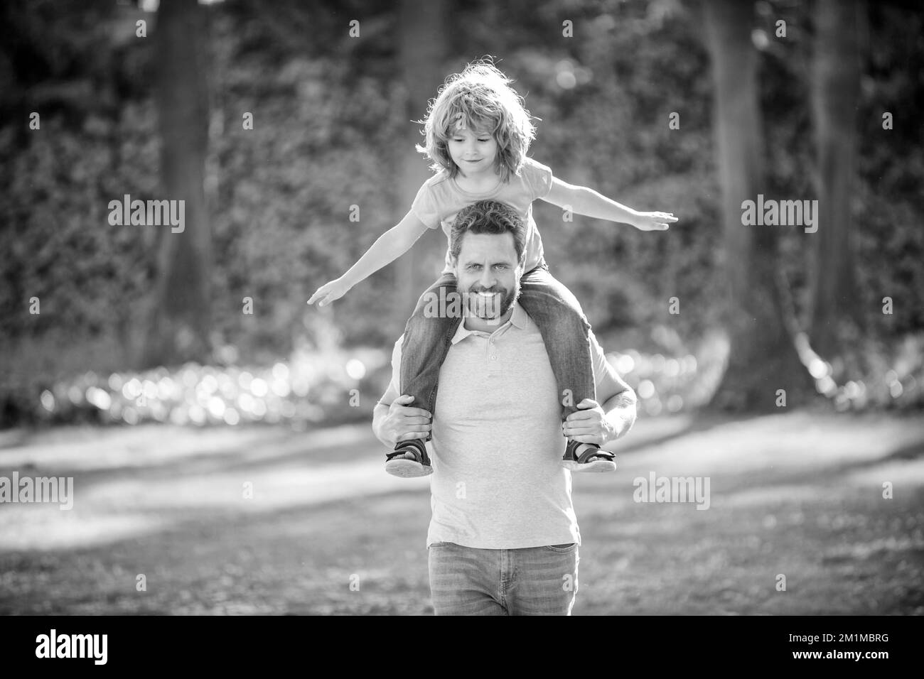 Ill give a piggy-back ride. Happy man carry son sitting on shoulders. Happy kid ride piggy-back Stock Photo