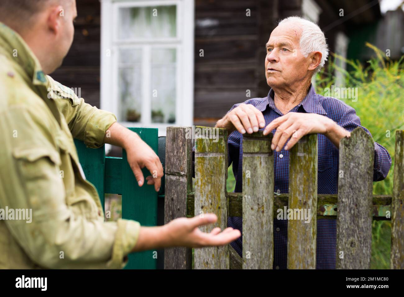 Old man talking with his neighbour Stock Photo