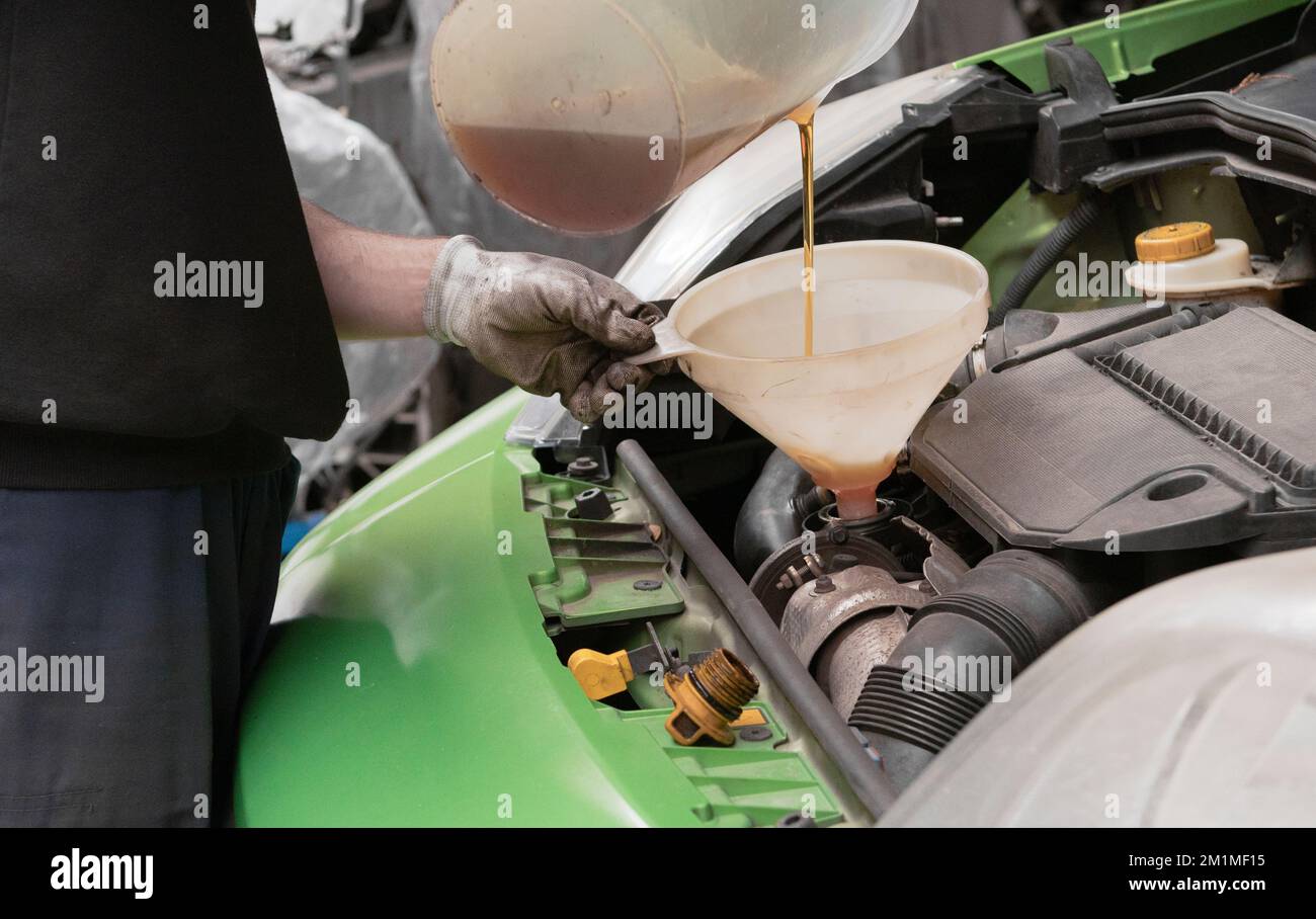 Refueling and pouring oil into the engine motor car. Maintenance and