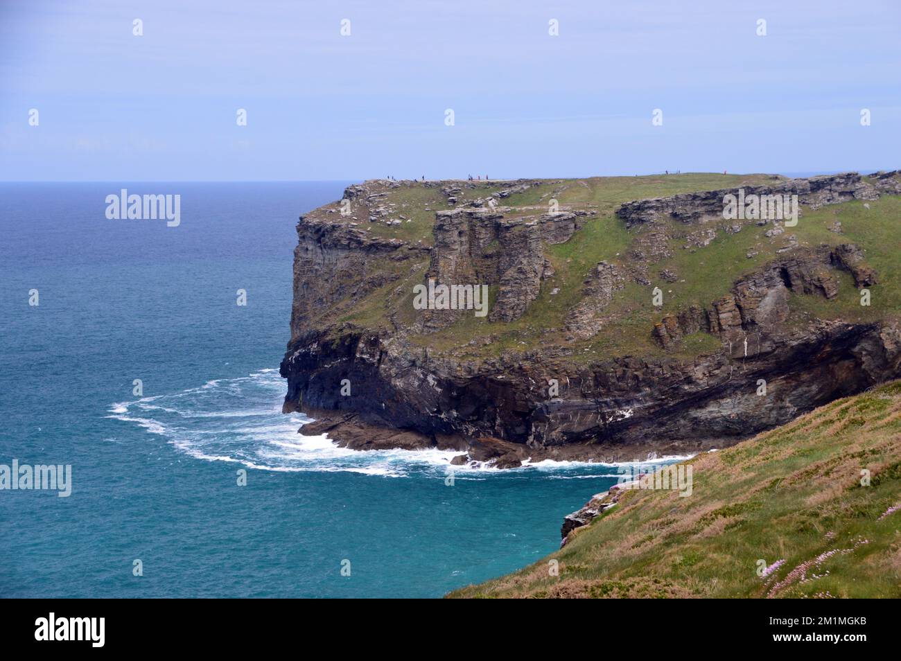 People Walking on Amongst the Ruins of Tintagel Castle on Tintagel Island from Glebe Cliff on the South West Coastal Path in Cornwall, England, UK. Stock Photo