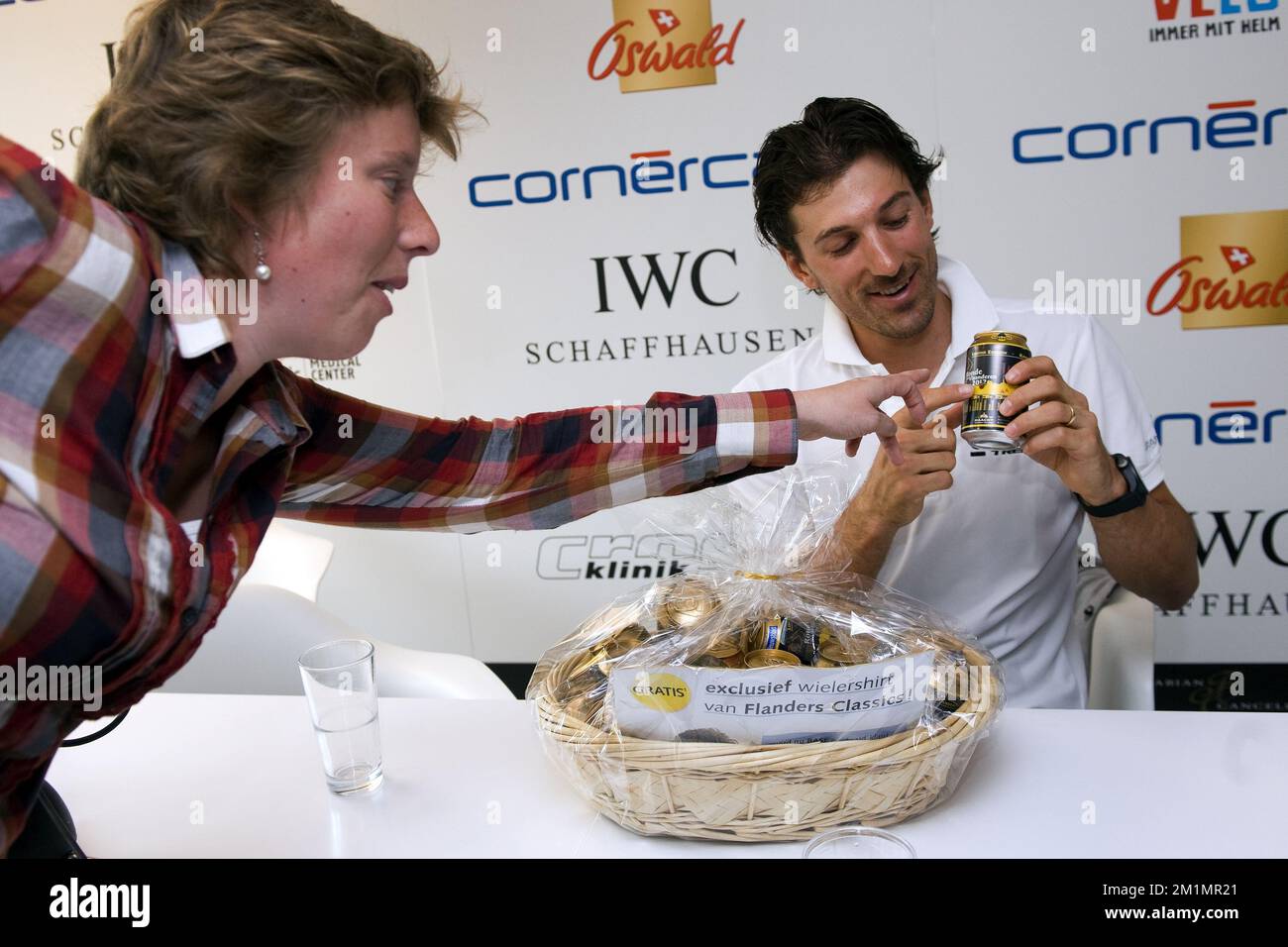 20120403 - BASEL, SWITZERLAND: Journalist Ann Braekman (L) offers a gift to Swiss cycling champion Fabian Cancellara during a press conference update of Swiss Fabian Cancellara of Team Radioshack Nissan Trek cycling team after the crash in which he fractured his right collarbone in four places, during the 96th edition of the 'Ronde van Vlaanderen - Tour des Flandres - Tour of Flanders' one day cycling race, in the Crossklinik, in Basel, Tuesday 03 April 2012. The bone was put together using a special technique allowing a better and faster recovery. Fabian Cancellara also announced that he is t Stock Photo