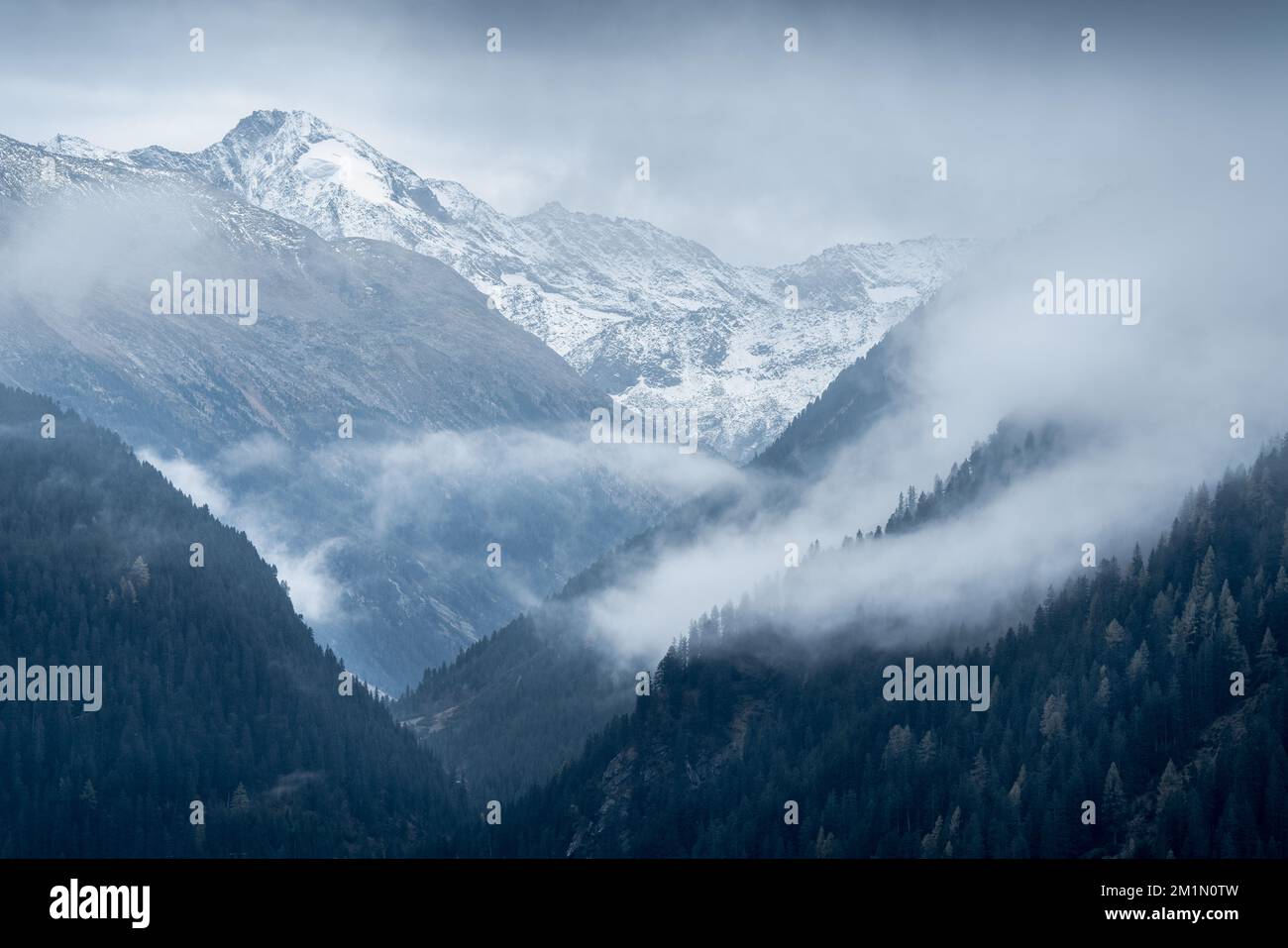 Dreiherrnspitze, Picco dei Tre Signori mountain in the back with dramatic mountain slopes on a cloudy and rainy day in Austrian-Italian Alps. Snow and Stock Photo