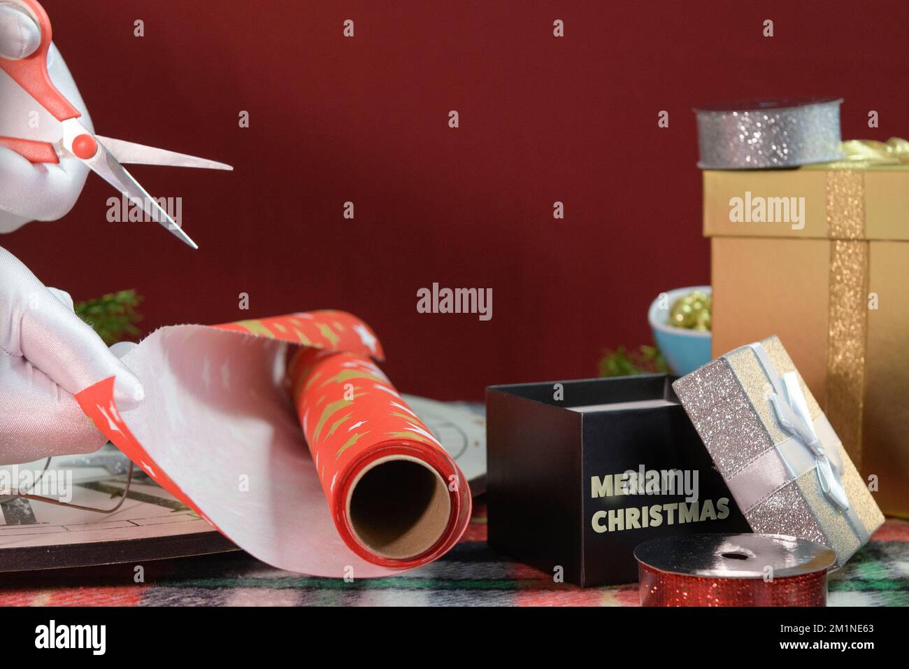 Packing of Christmas gifts. hands in white gloves with scissors cut