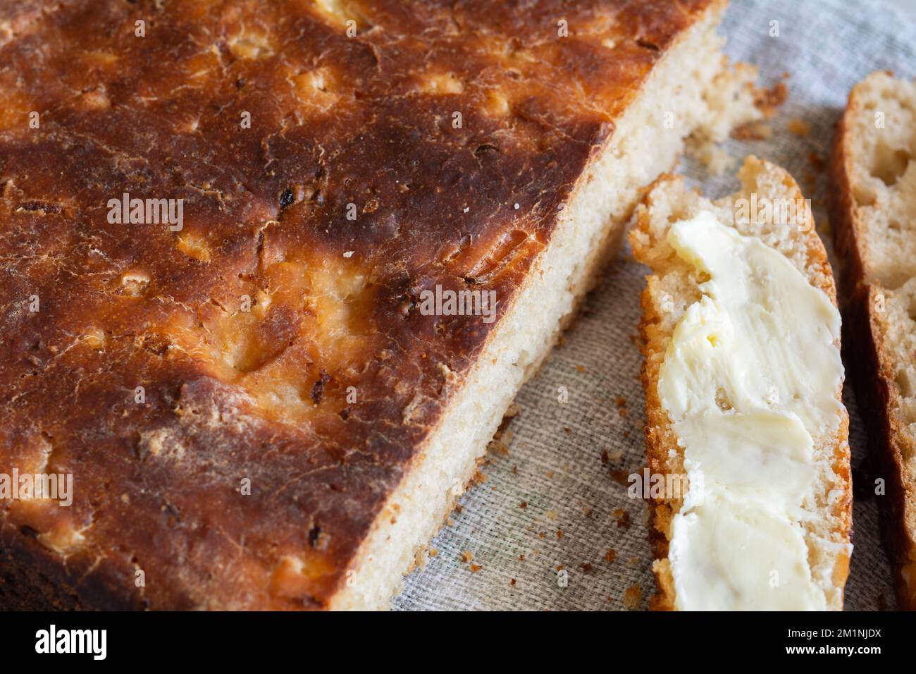 Homemade artisan bread and slices of buttered bread, close-up. Concept ...