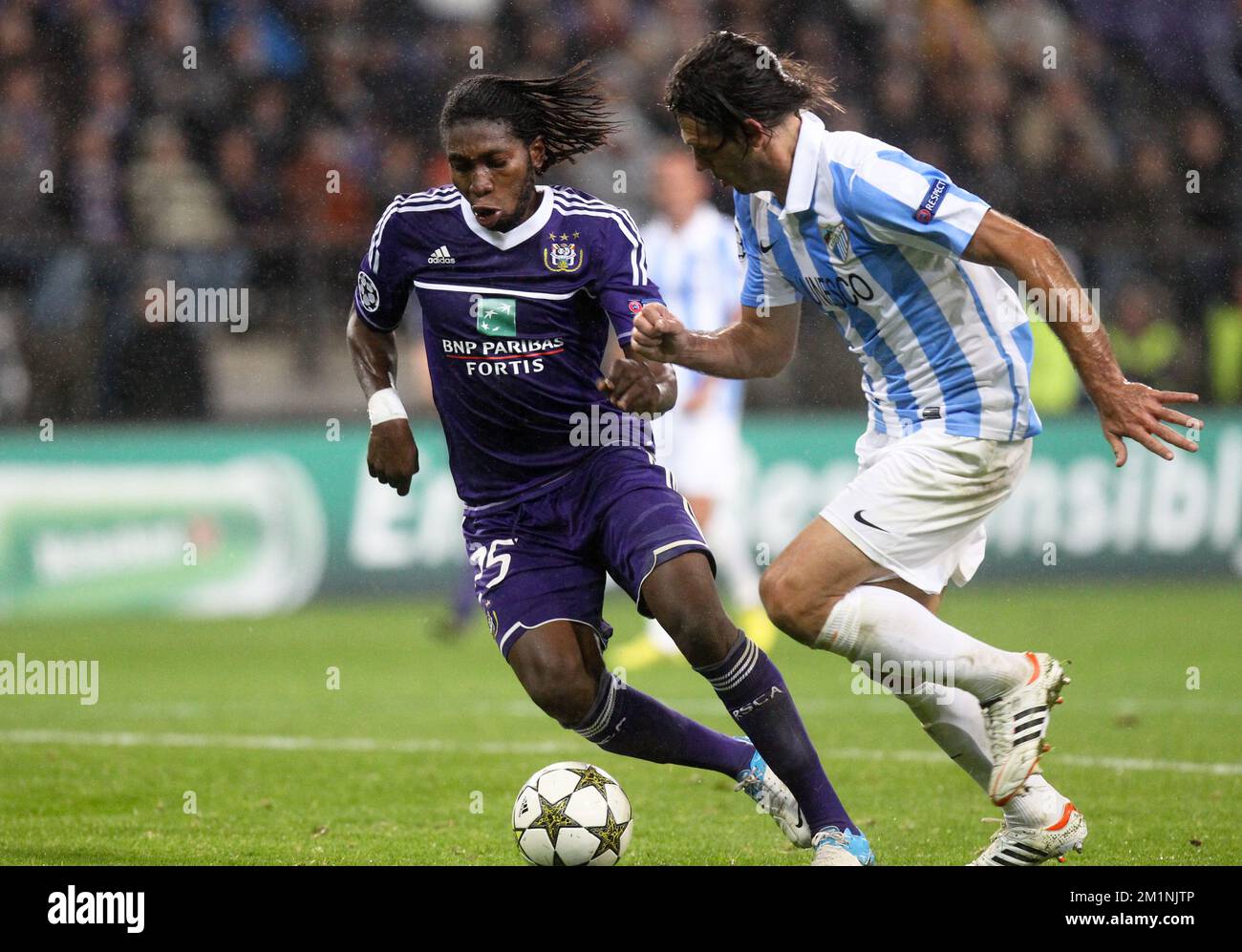20121003 - BRUSSELS, BELGIUM: Anderlecht's Dieumerci Mbokani and Malaga's defender Martin Demichelis fight for the ball during the match between RSCA Anderlecht and Spanish club Malaga CF, on the second day of the group stage (group C) of the UEFA Champions League tournament, in Brussels, Wednesday 03 October 2012. BELGA PHOTO VIRGINIE LEFOUR Stock Photo