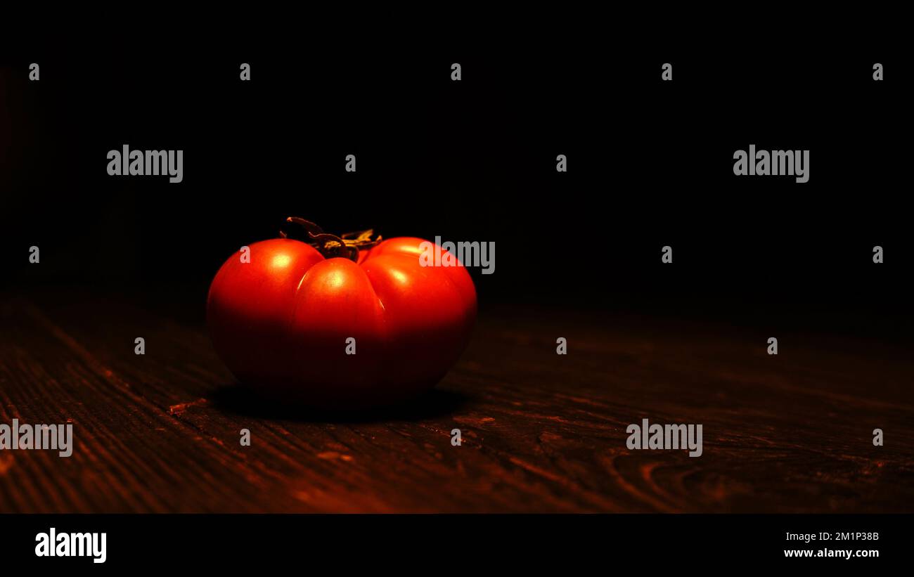 Tomato on wooden table with black background Stock Photo - Alamy