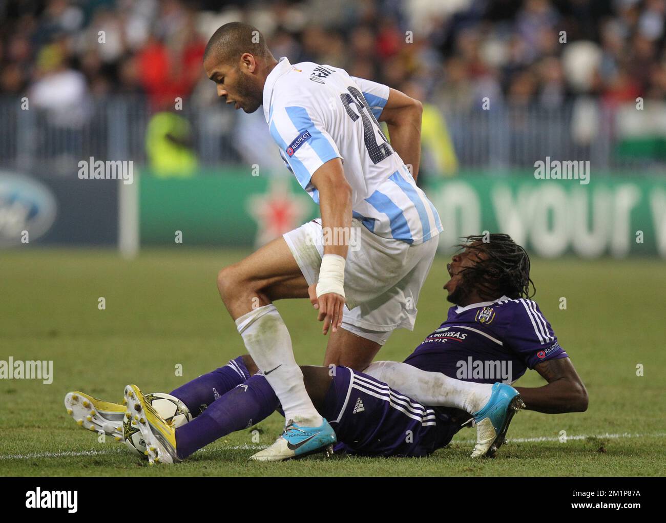 20121204 - BRUSSELS, SPAIN: Malaga's defender Oguchi Onyewu and Anderlecht's Dieumerci Mbokani fight for the ball during the match between Spanish club Malaga CF and Anderlecht, in the group stage (group C) of the UEFA Champions League tournament, in Malaga, Tuesday 04 December 2012. BELGA PHOTO VIRGINIE LEFOUR Stock Photo