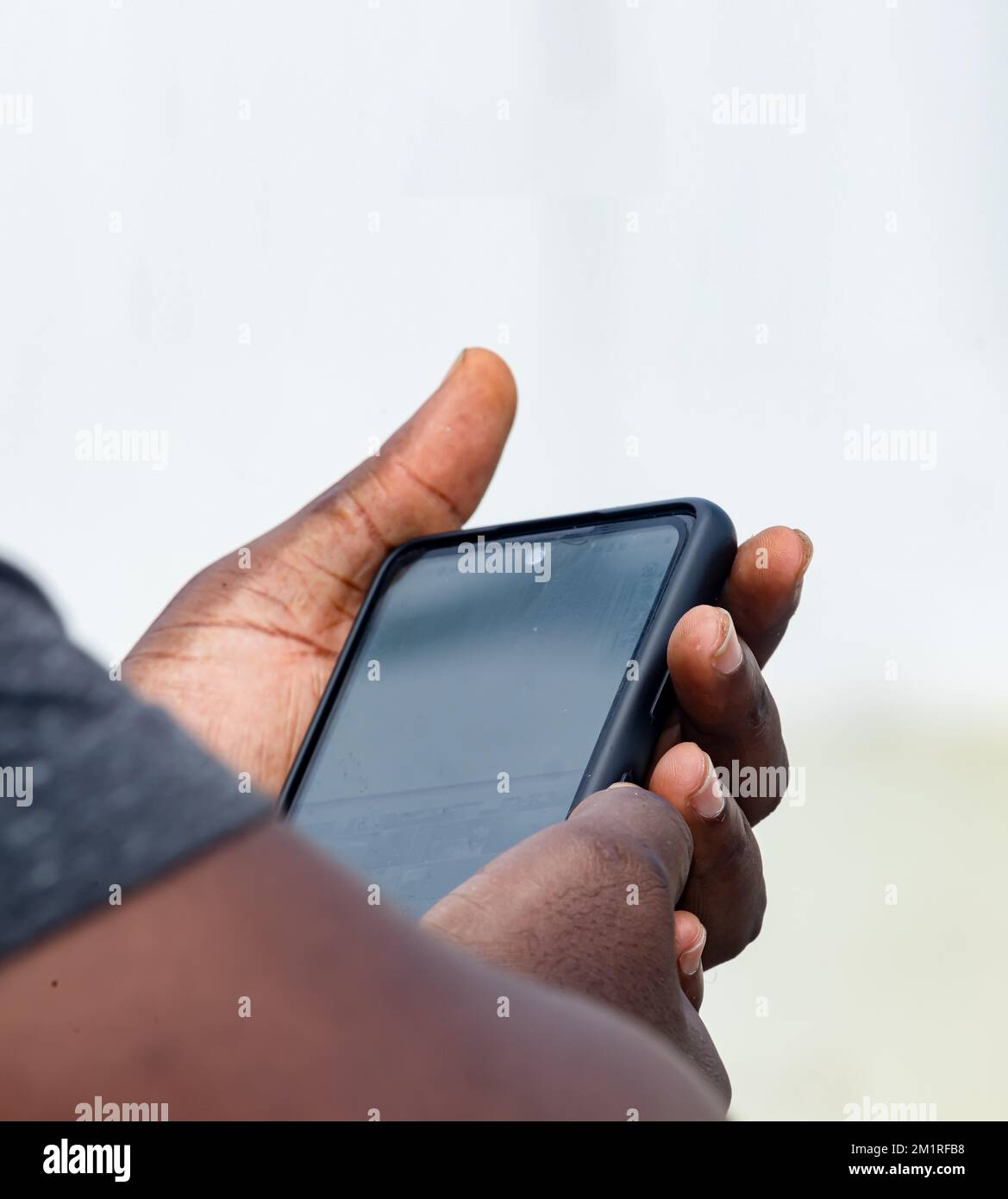 African businessman hand holding black smartphone Stock Photo