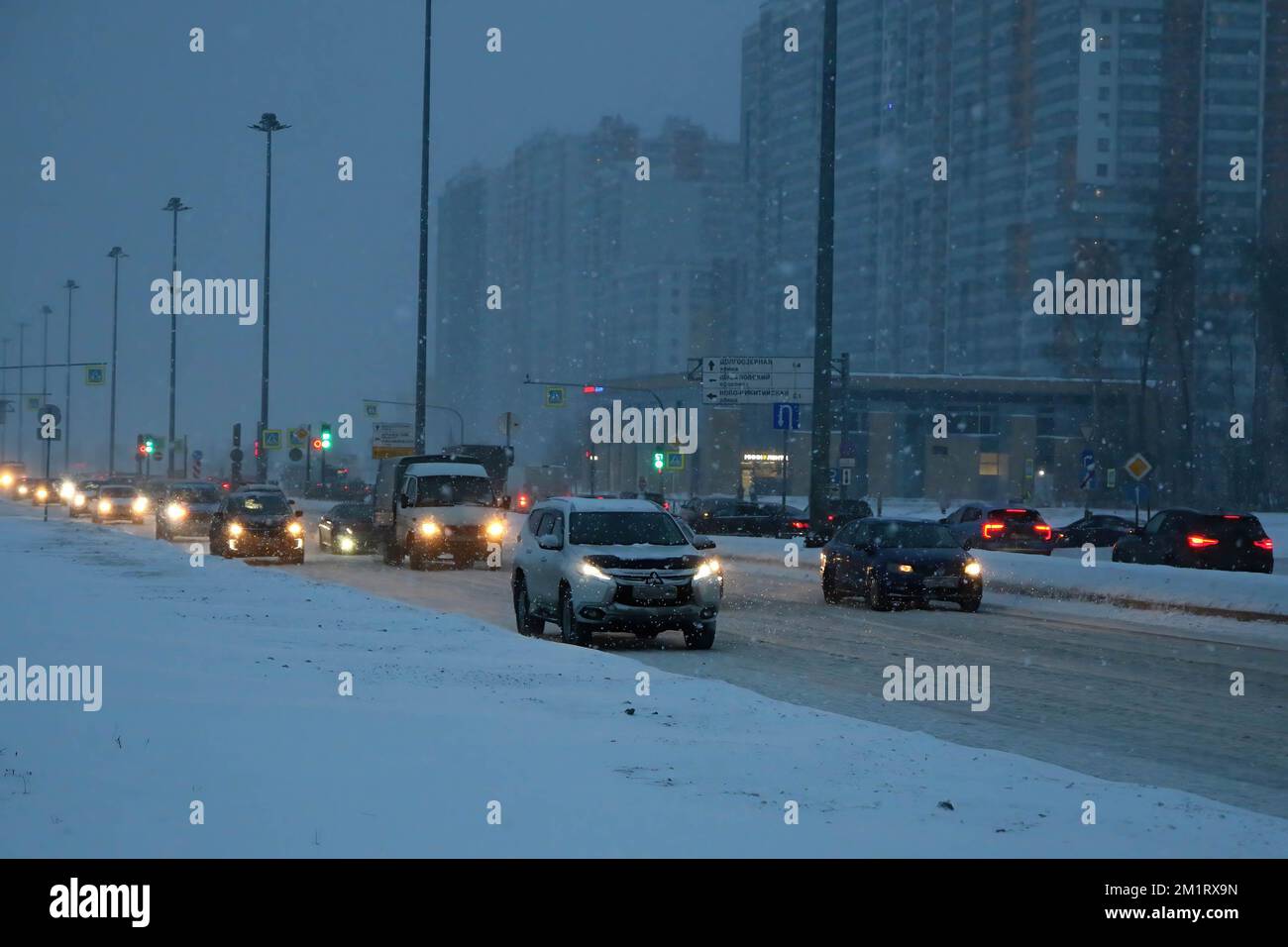 Cars drive on the road during a heavy snowfall and blizzard brought by ...