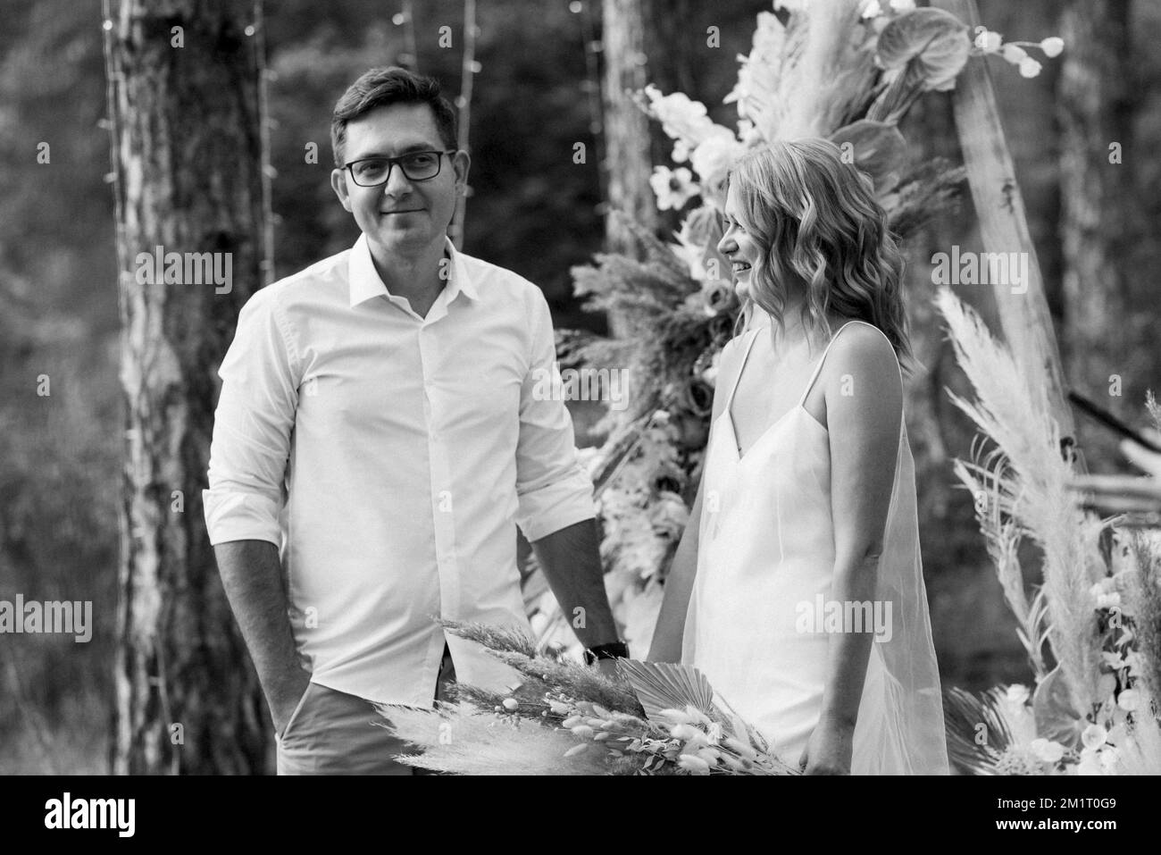 wedding ceremony of the marriage of a guy and a girl against the backdrop of an arch on a forest