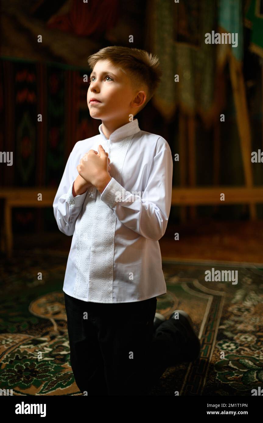 The boy is kneeling in prayer to God Stock Photo - Alamy