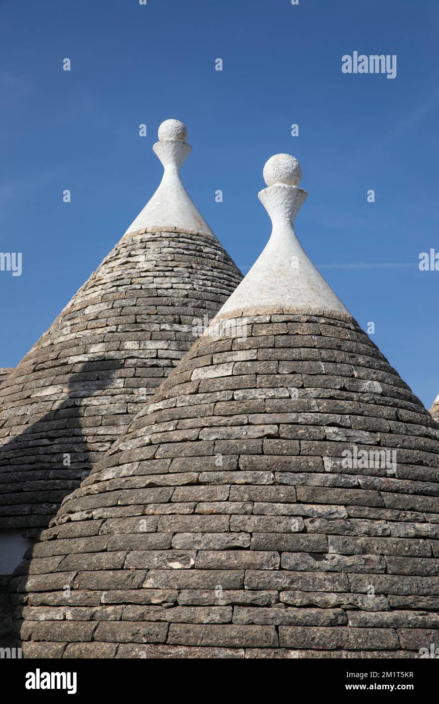 Conical roofs of trulli buildings with decorative pinnacles in the Valle d'Itria, Puglia, Italy, Europe Stock Photo