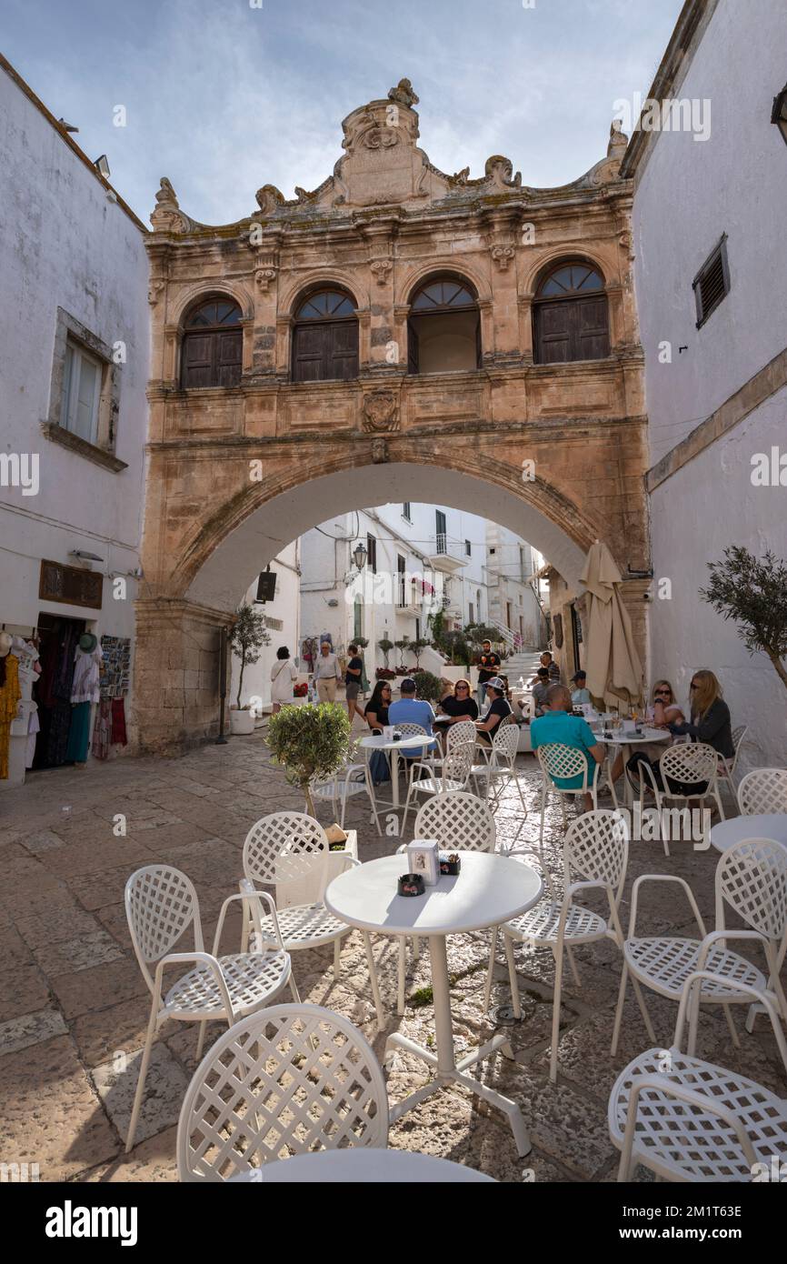 Arco Scoppa arch and cafe in the Largo Arcid Teodoro Trinchera square, Ostuni, Brindisi province, Puglia, Italy, Europe Stock Photo