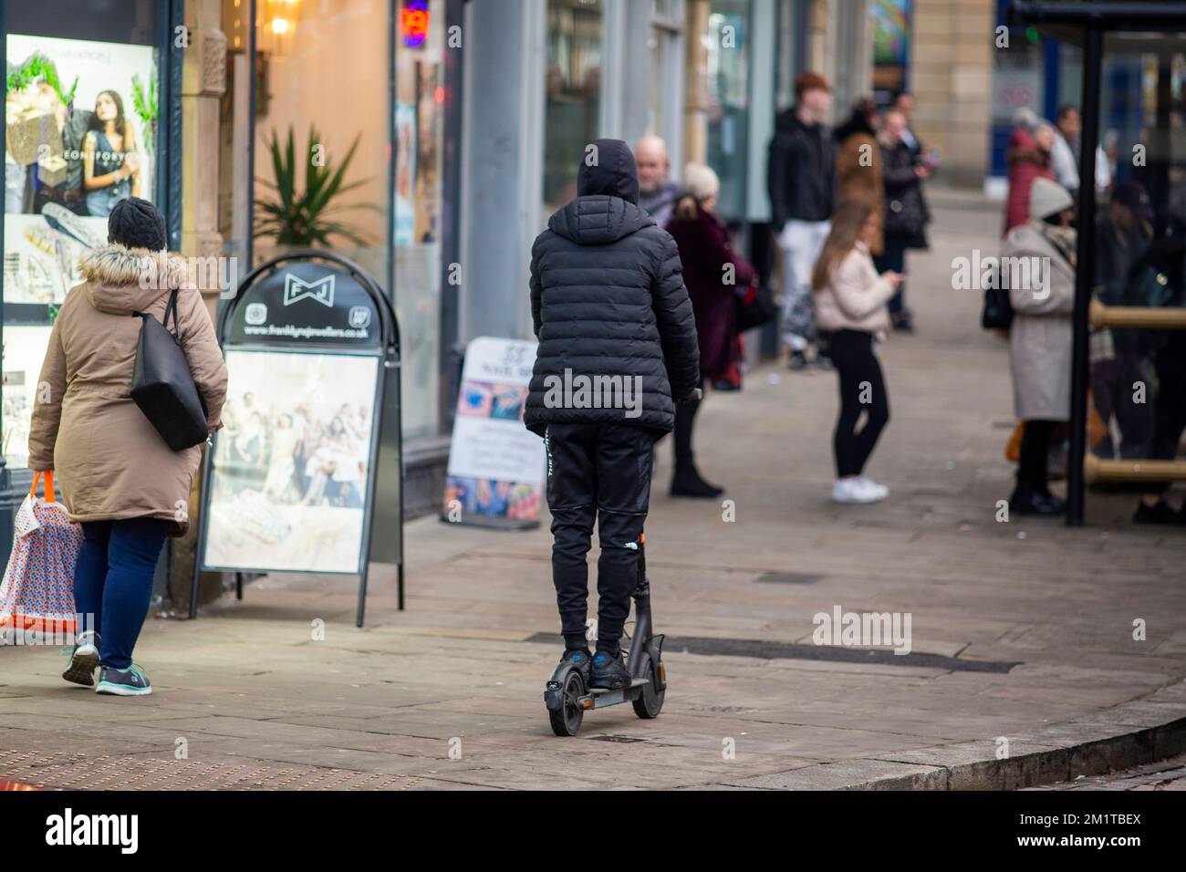 A young person on a electric scooter (e scooter ) rides on the pavement