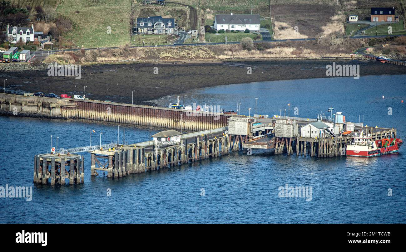 A boat alongside the Jetty at Uig, Isle of Skye, with the village behind. Stock Photo