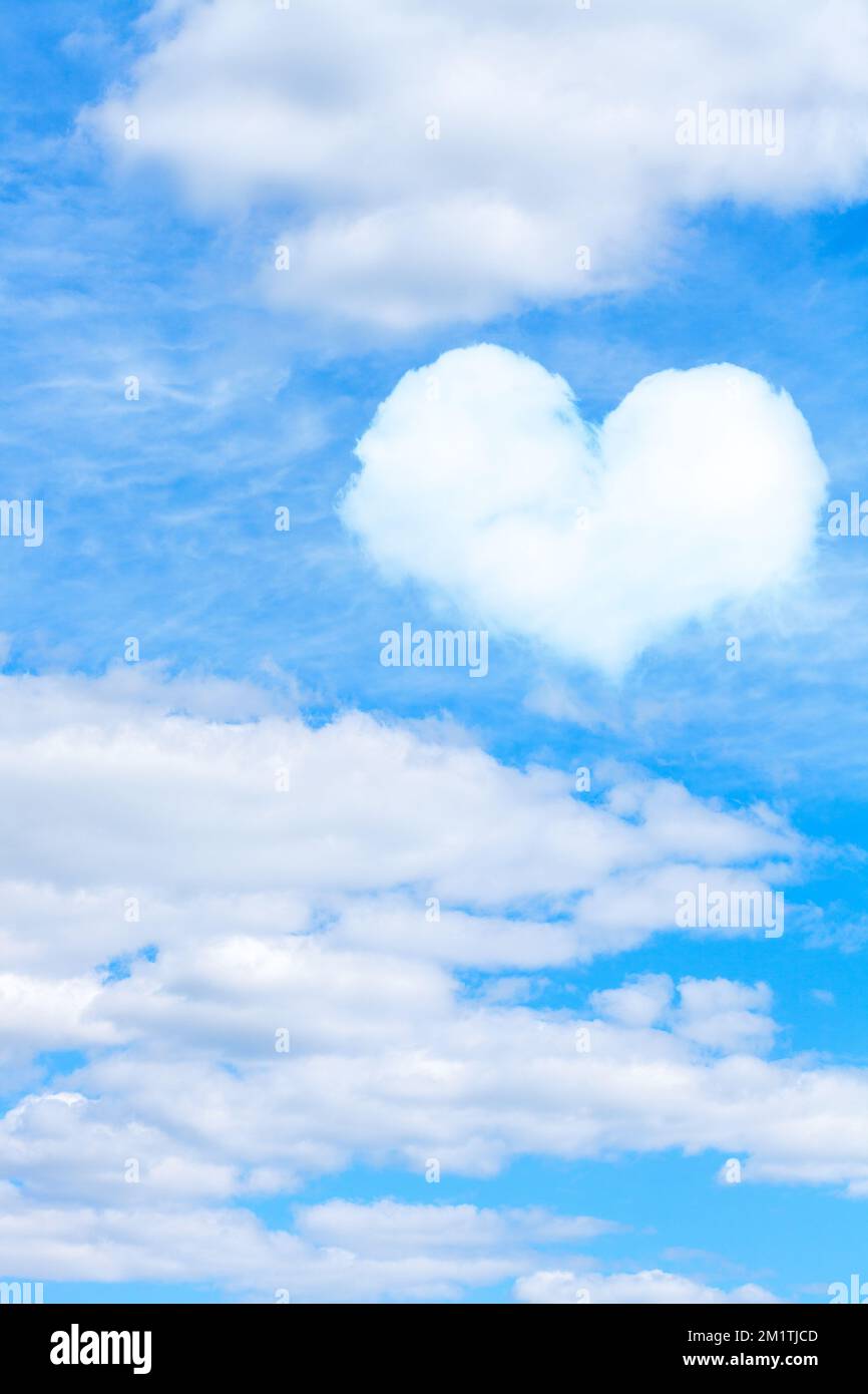 cumulus clouds on blue sky with heart shaped cloud. vertical frame ...