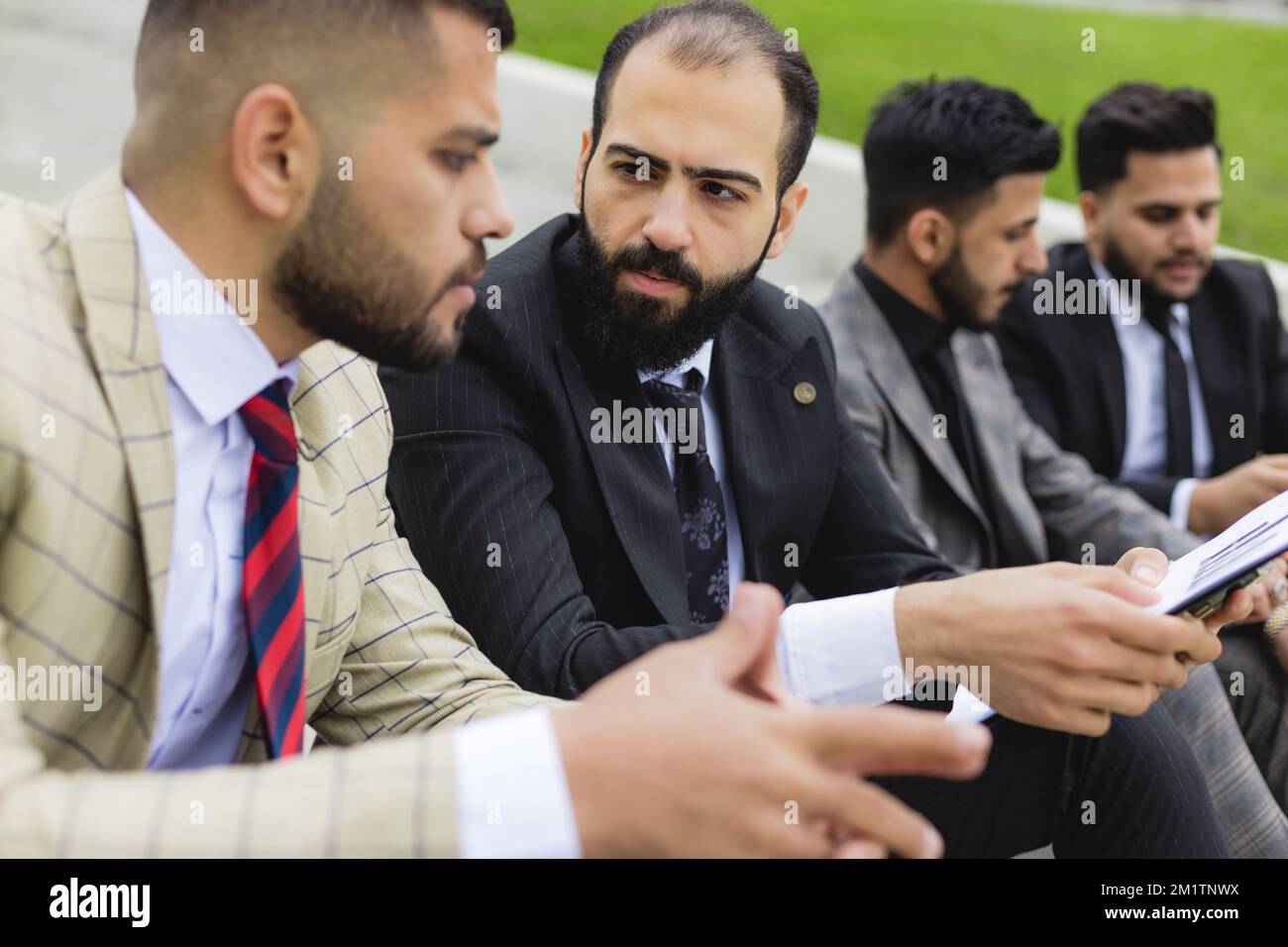 Business people outdoor meeting. A company of male businessmen in suits ...