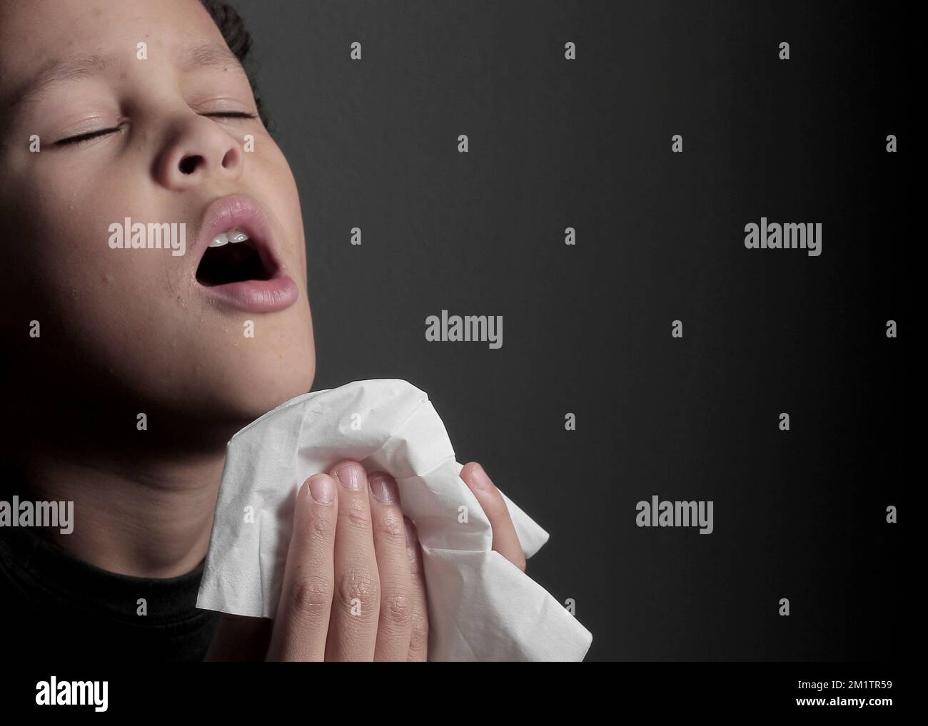 catching the flu child blowing nose after catching a cold with grey