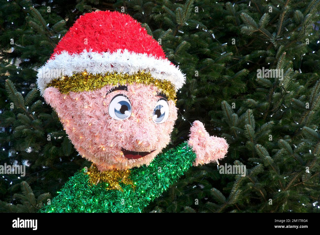 Santa’s little helper. A glittering comic figure of a Christmas elf made with tinsel and fairy lights in the main shopping area of Weymouth in Dorset. Stock Photo
