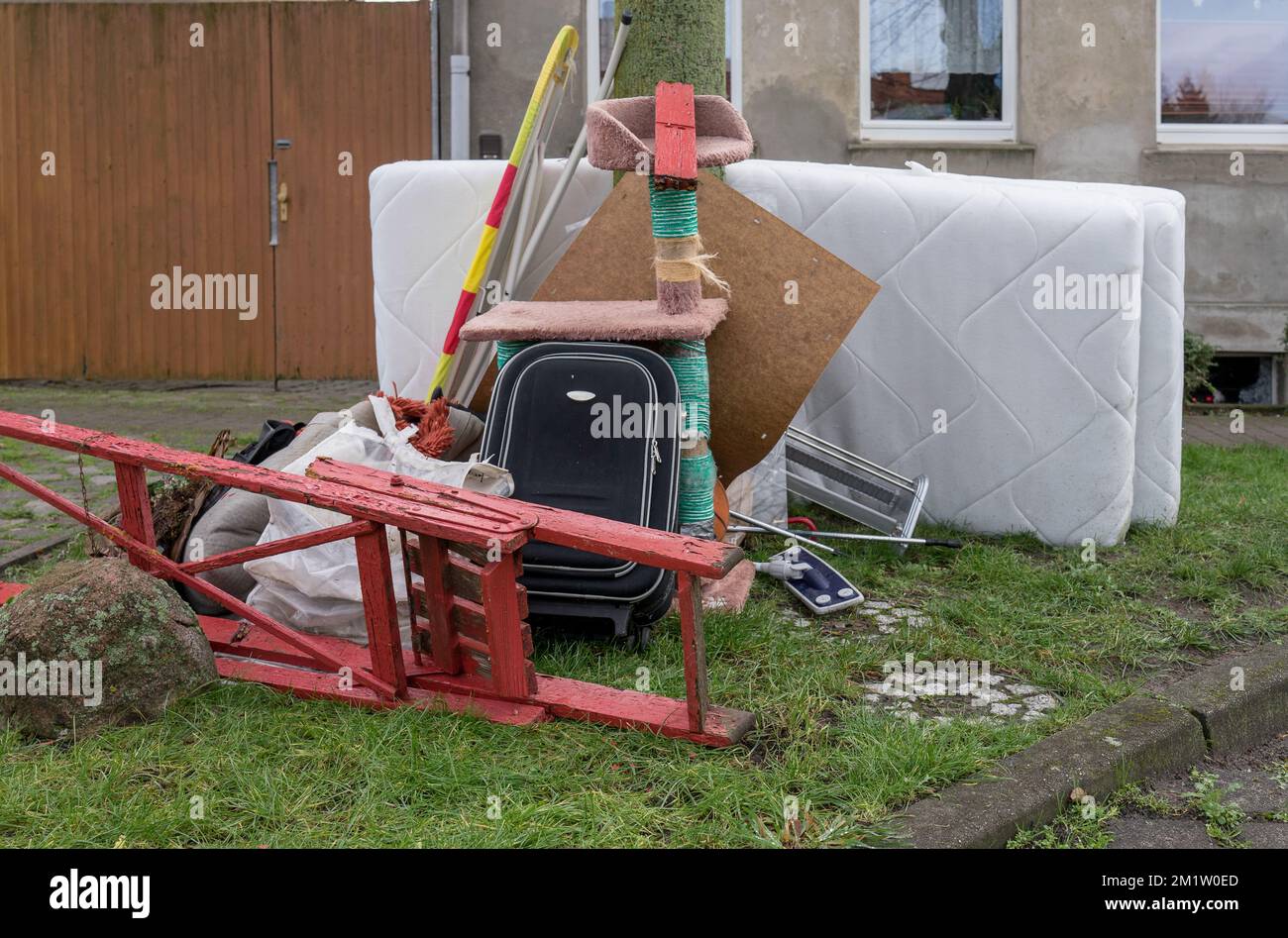 Bulky garbage heap with mattresses, ironing board and red ladder Stock