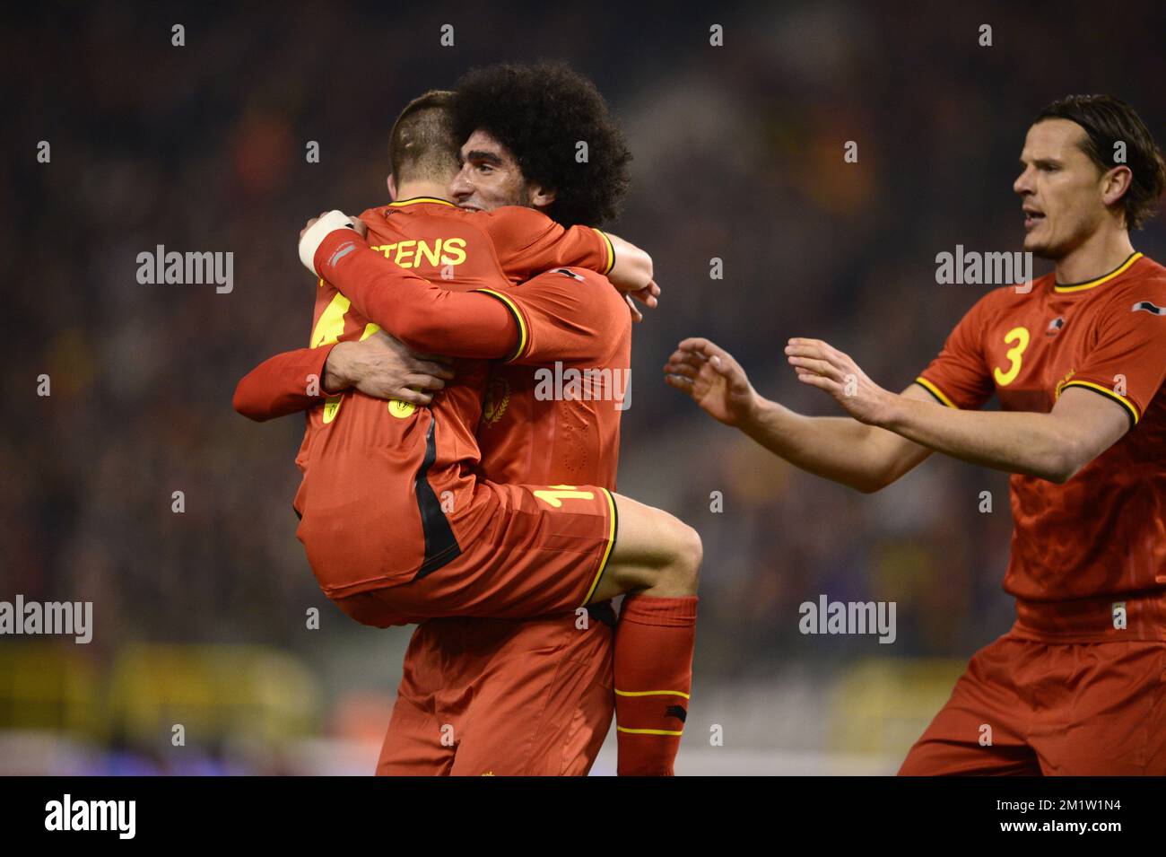 Belgium's Marouane Fellaini celebrates with Dries Mertens (L) and Daniel Van Buyten (R) after scoring the 1-0 goal during a friendly soccer game between the Belgian national team the Red Devils and Ivory Coast, Wednesday 05 March 2014 in Brussels.  Stock Photo