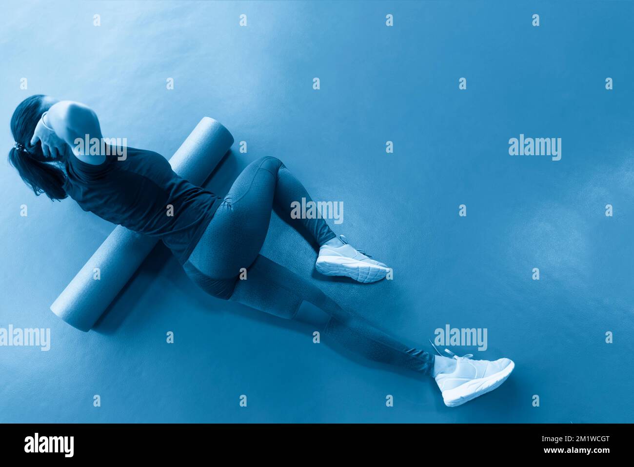 Woman doing foam roller exercise on a floor in gym Stock Photo - Alamy