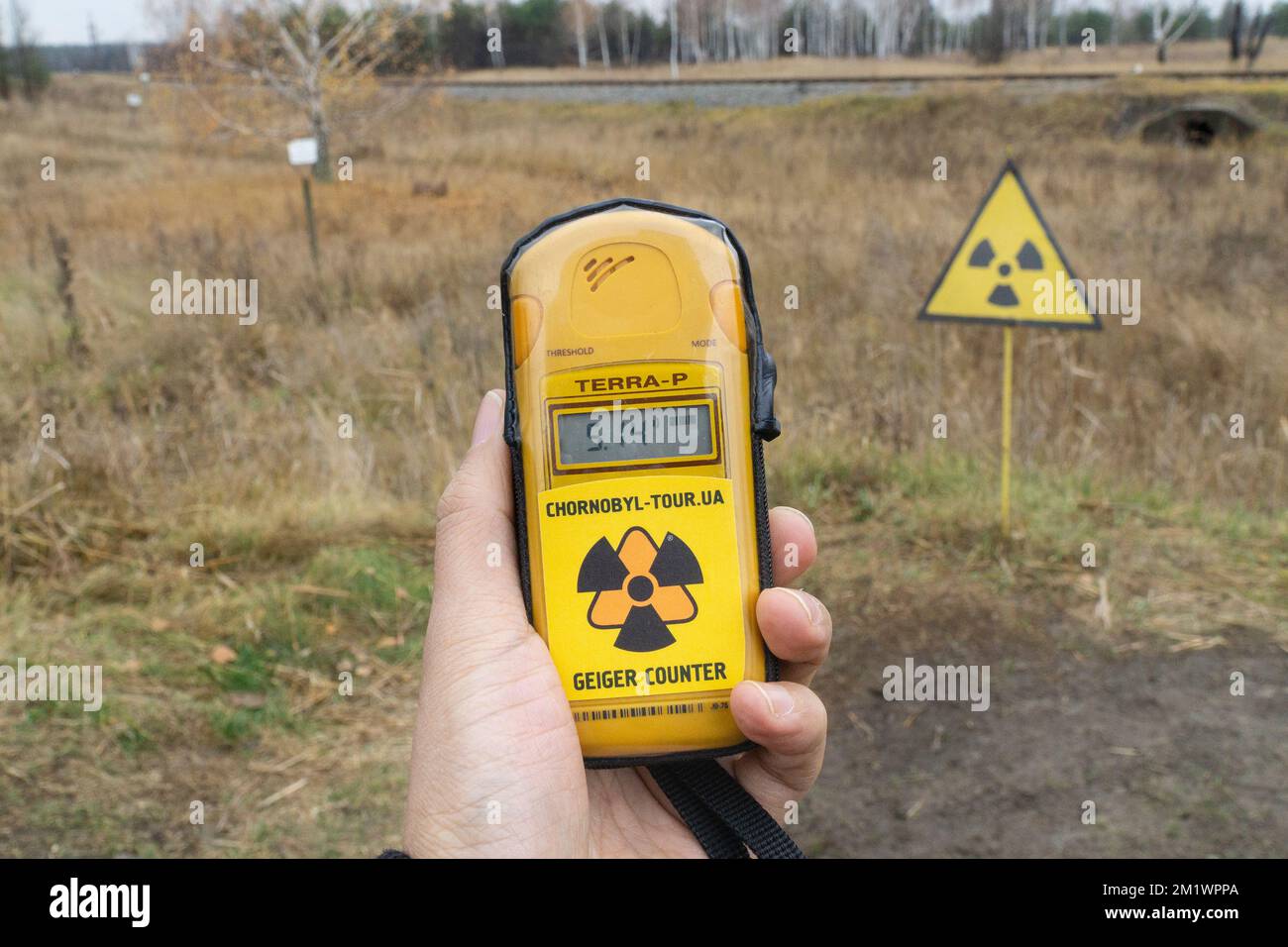 Close up to a geiger counter with radiation levels and a radioactive