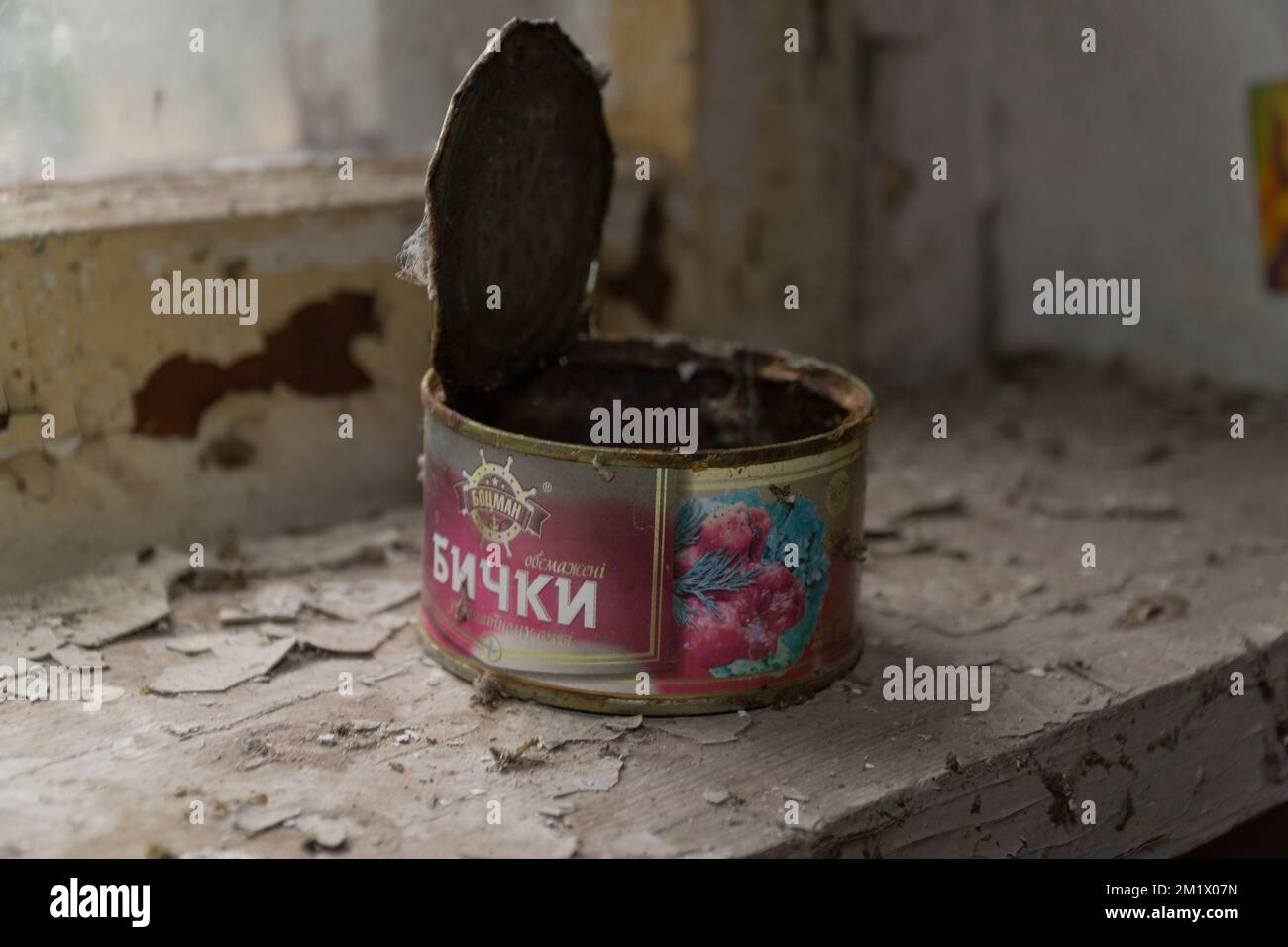 Old canned food open over a rusty wooden window corner inside a pripyat ...