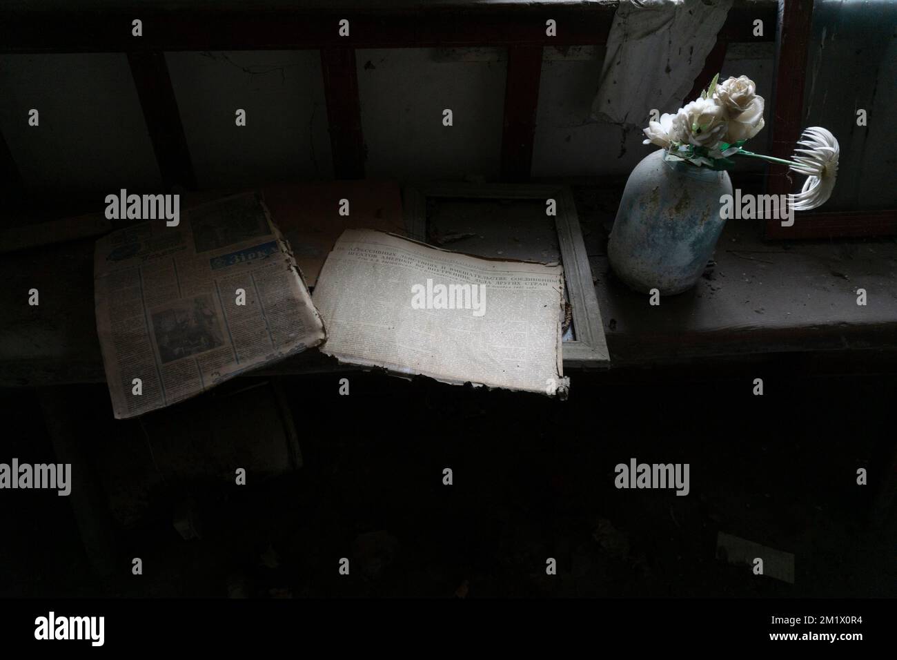 Old books and magazines with flowers over wooden table at chernobyl exclusion zone Stock Photo