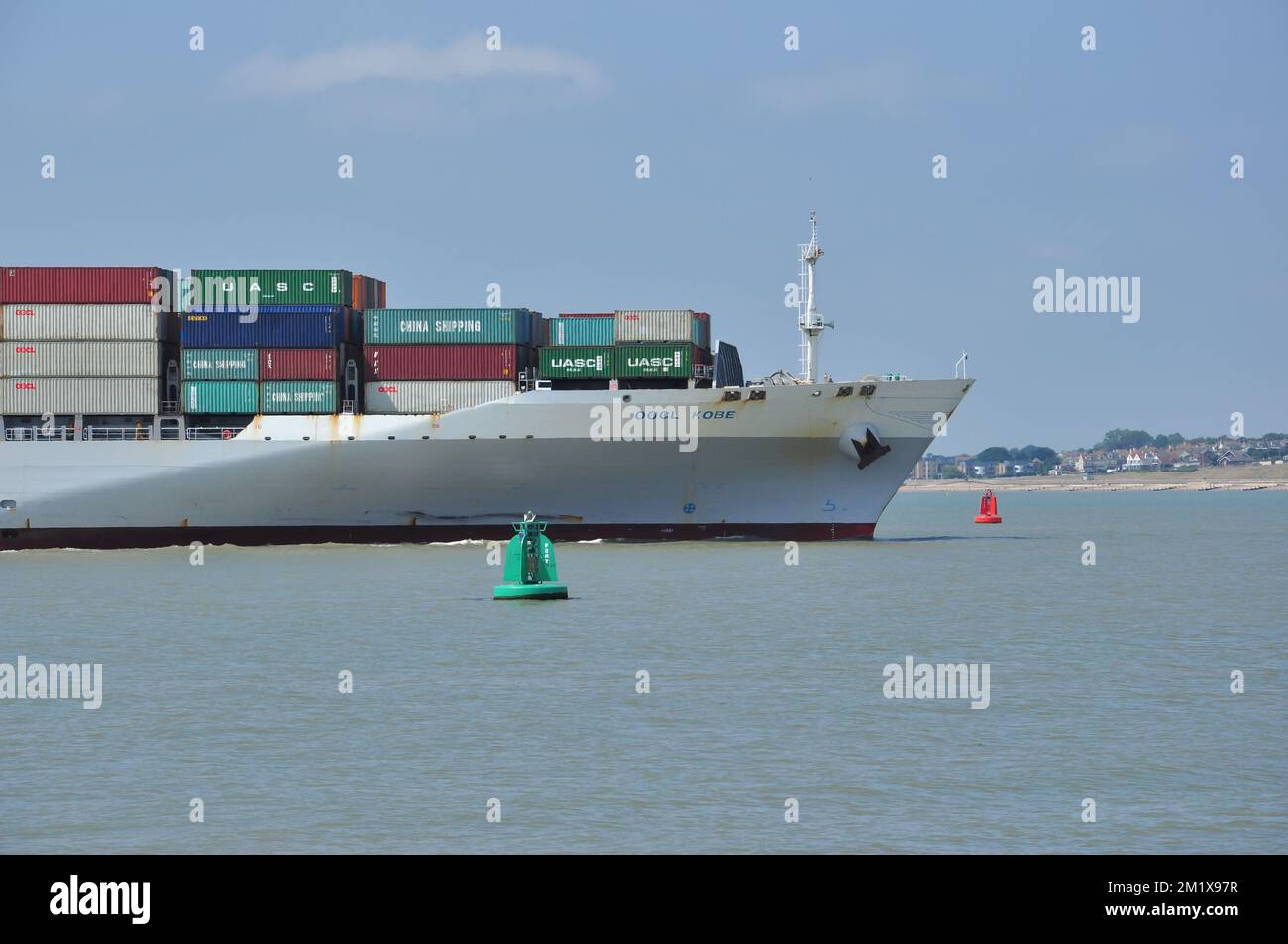 Container ship OOCL KOBE moves between navigation buoys on approach to Felixstowe, Suffolk, England, UK Stock Photo