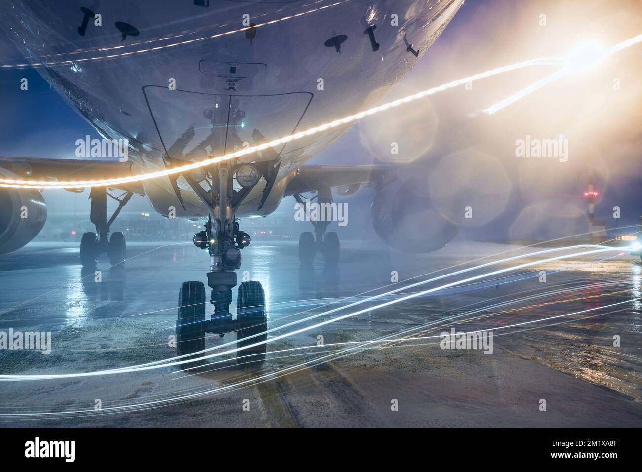 Airplane landing gear during the deicing process. Winter night at