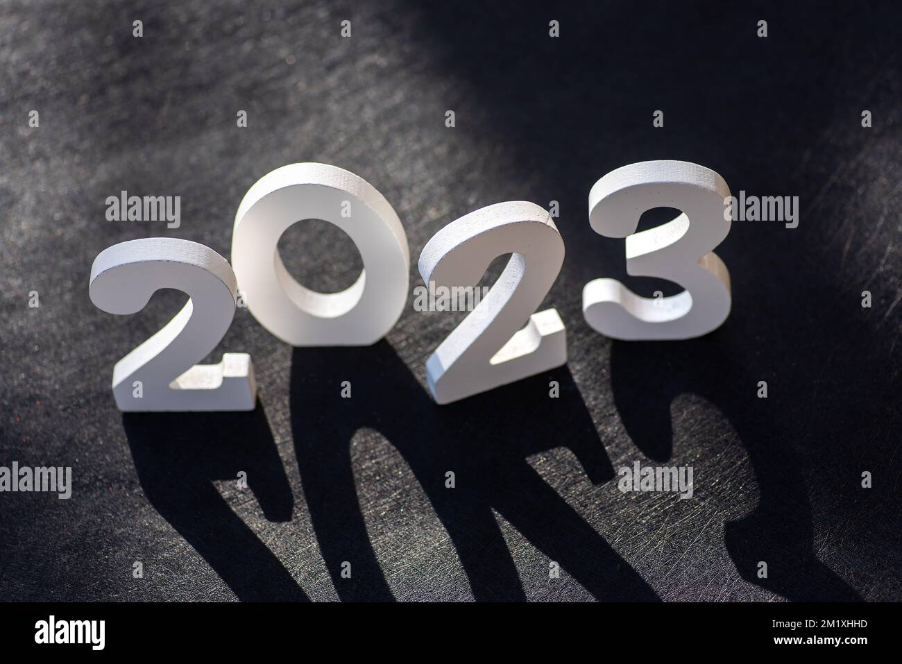 2023 New Year background card with large wooden letters and copy space. White painted wood created the inscription Number 2023 on a black background. Stock Photo