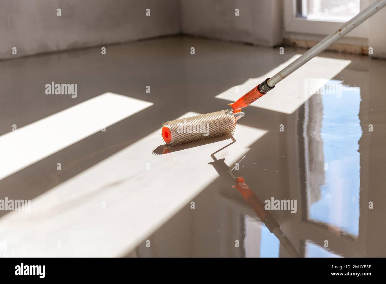 Needle roller for selfleveling floors. Leveling the floors with a cement mixture Stock Photo