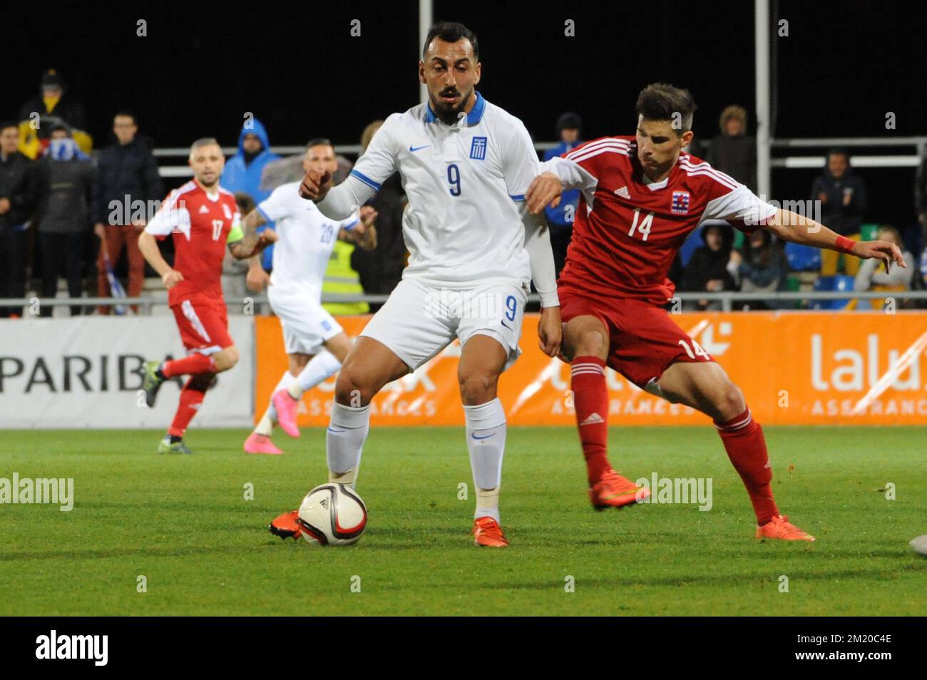 20151113 - DIFFERDANGE, LUXEMBOURG: Greece's Kostas Mitroglou and Luxembourg's Kevin Malget fight for the ball during a friendly soccer game between Luxembourg national team and Greece, in Differdange, Luxembourg, Friday 13 November 2015. BELGA PHOTO SOPHIE KIP Stock Photo