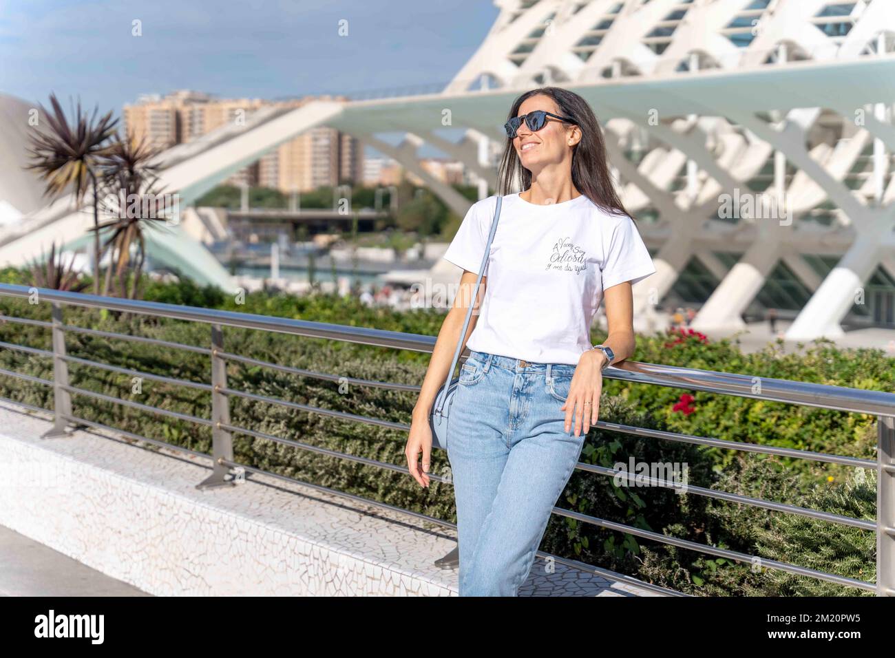 Brunette woman in white t-shirt and jeans in posing outside Stock Photo